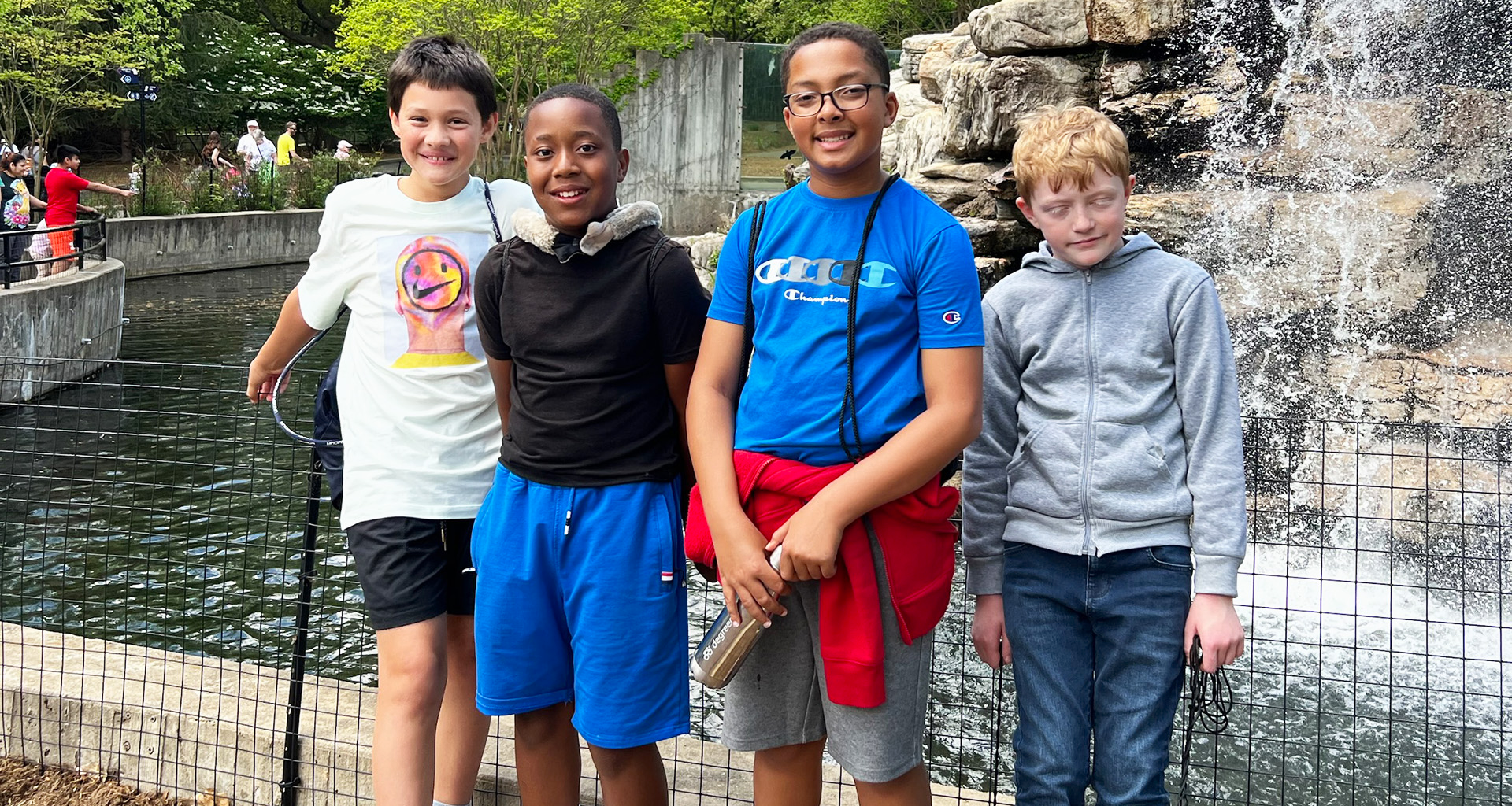 Four students pose on a field trip to the zoo