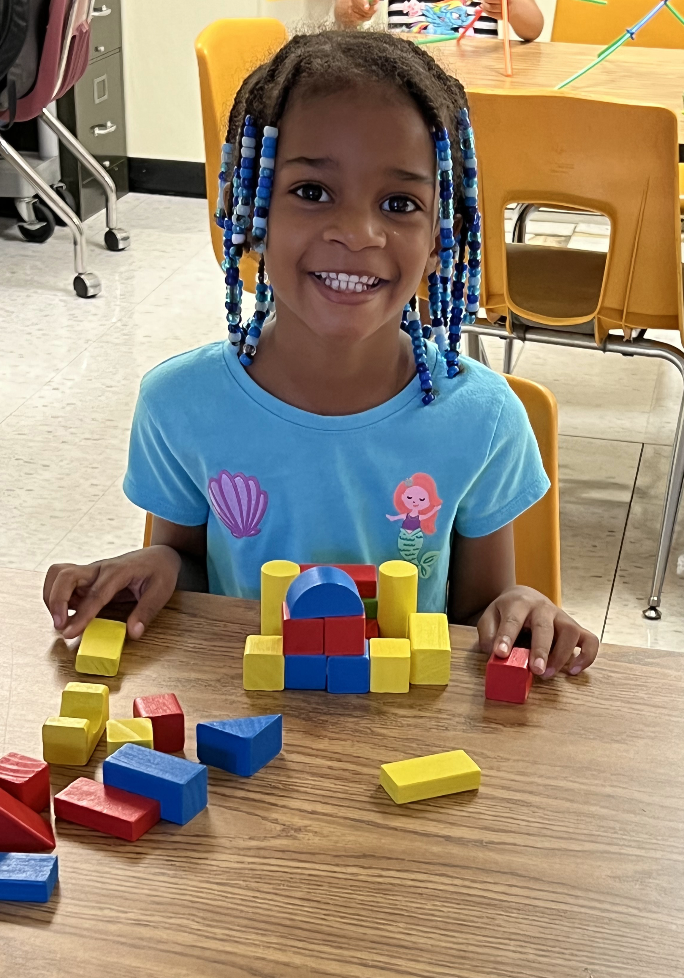 Girl smiling while playing with blocks
