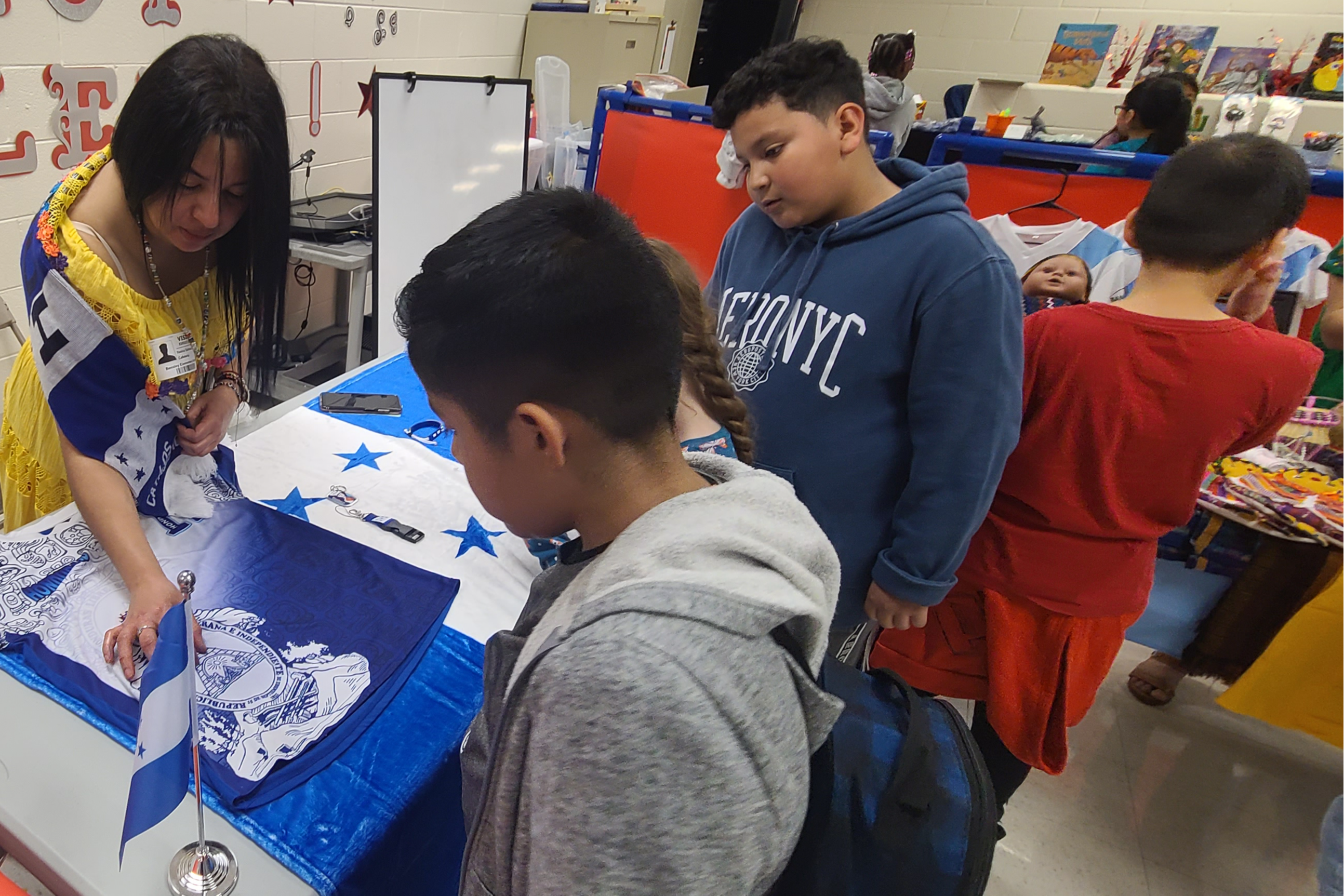 Students observing articles about a country on a table