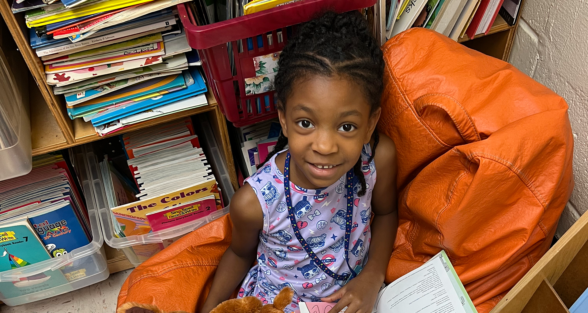 A little girl reading a book in class
