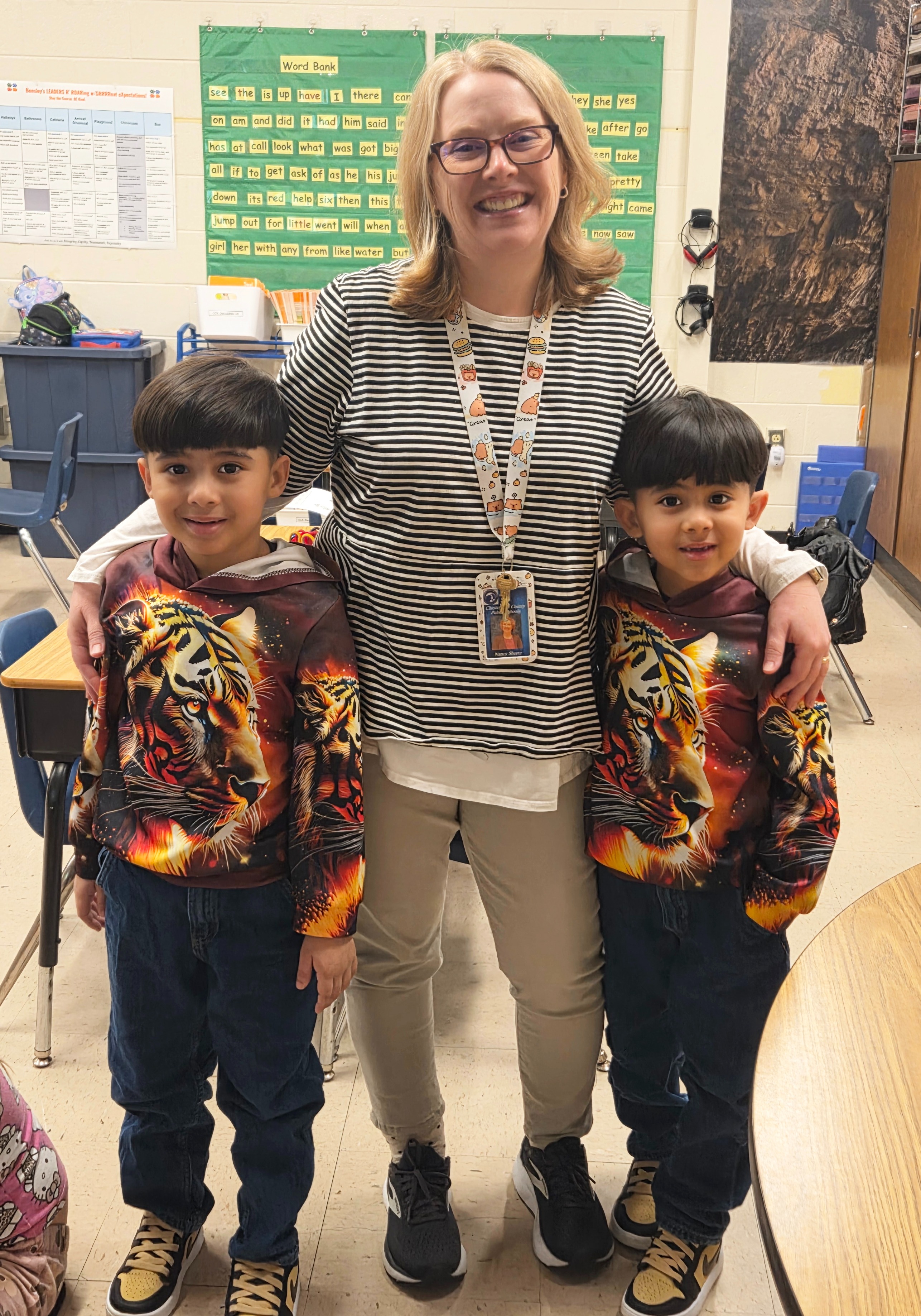 teacher hugging two students