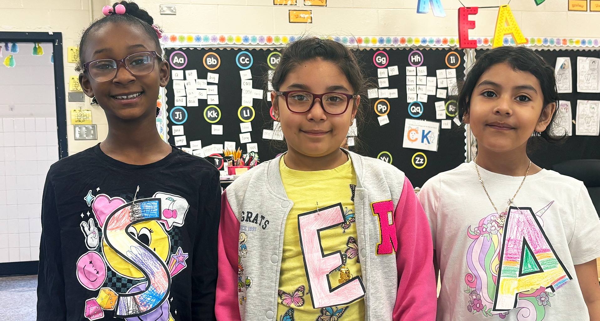 three students smile for a photo
