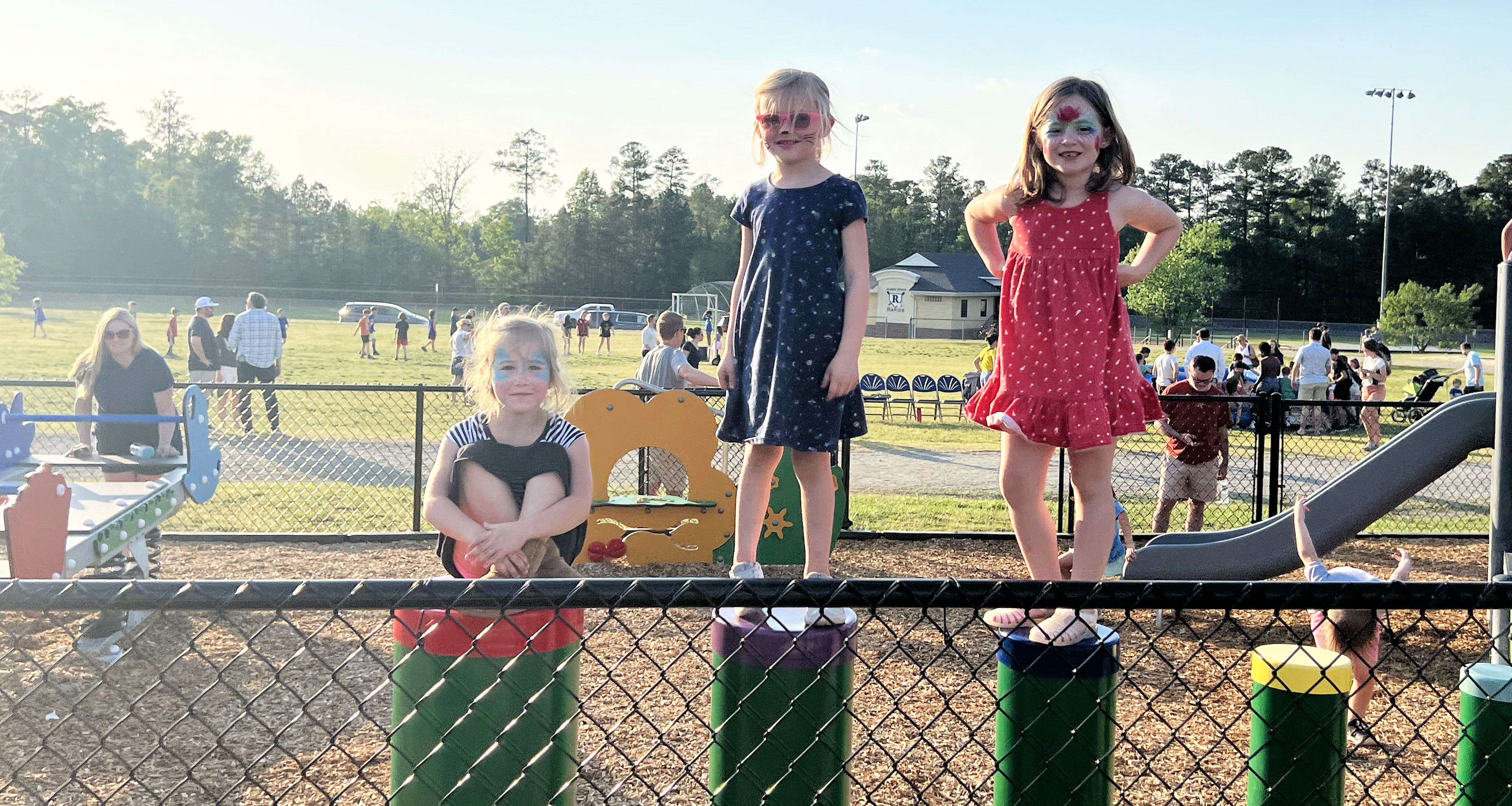 Three students standing on risers on the playground