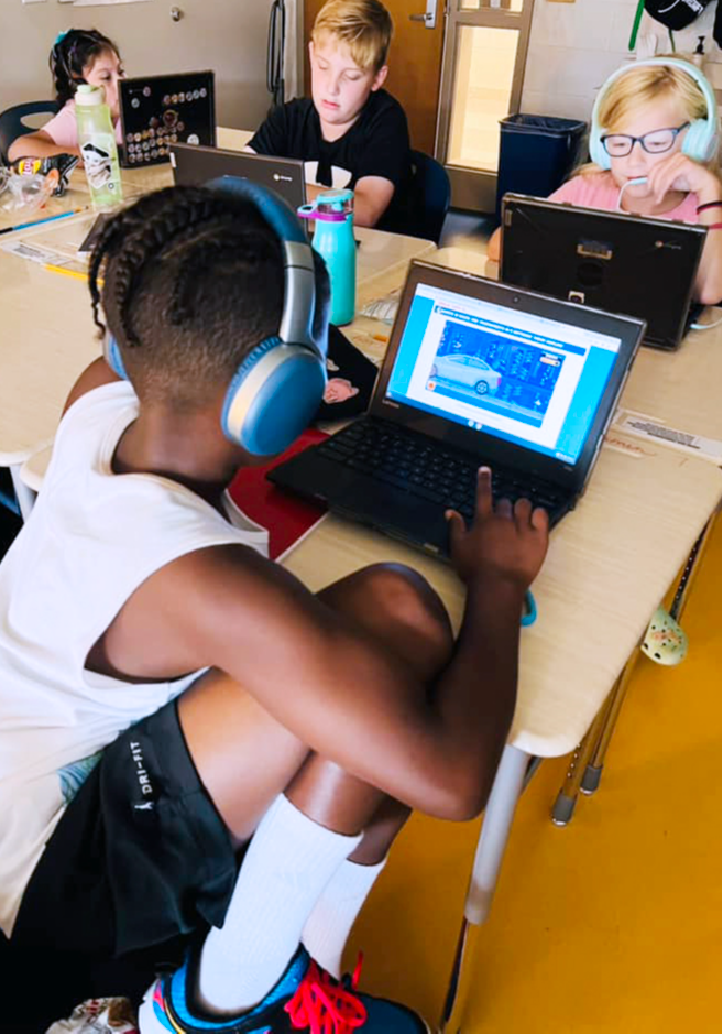 several students working at a table with headsets on