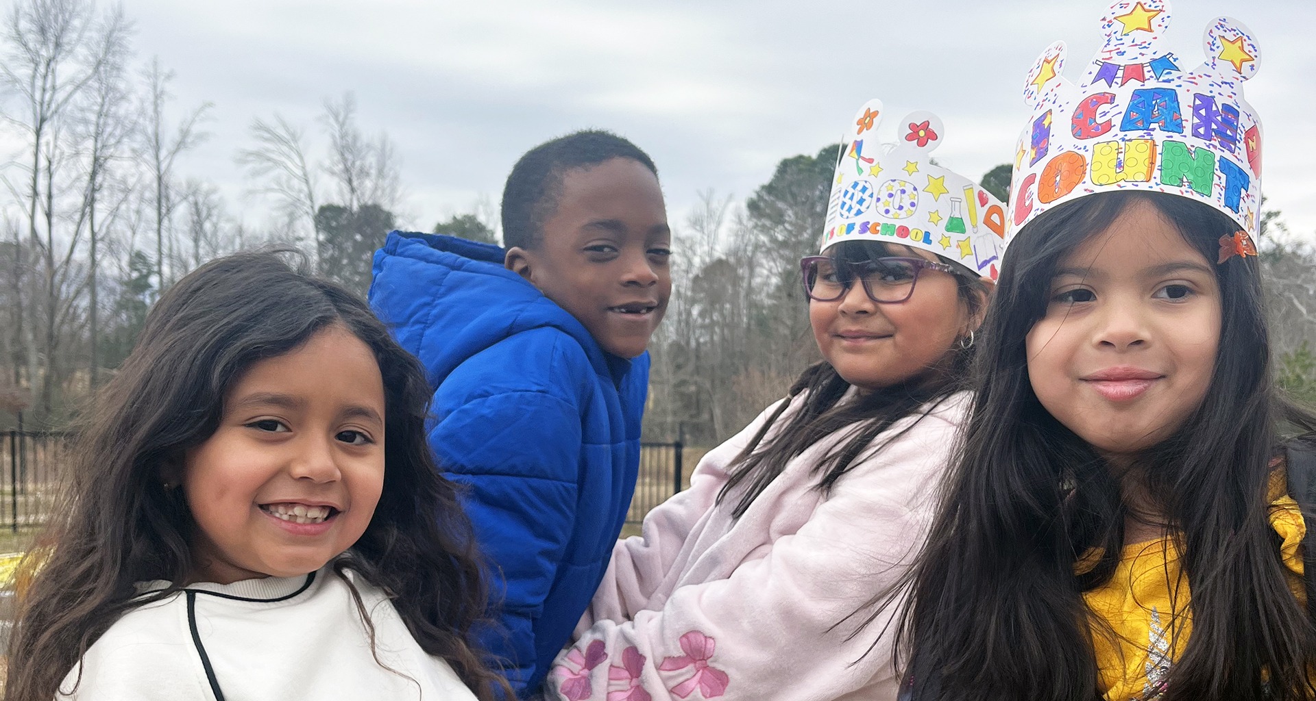 Four students pose on the playground.