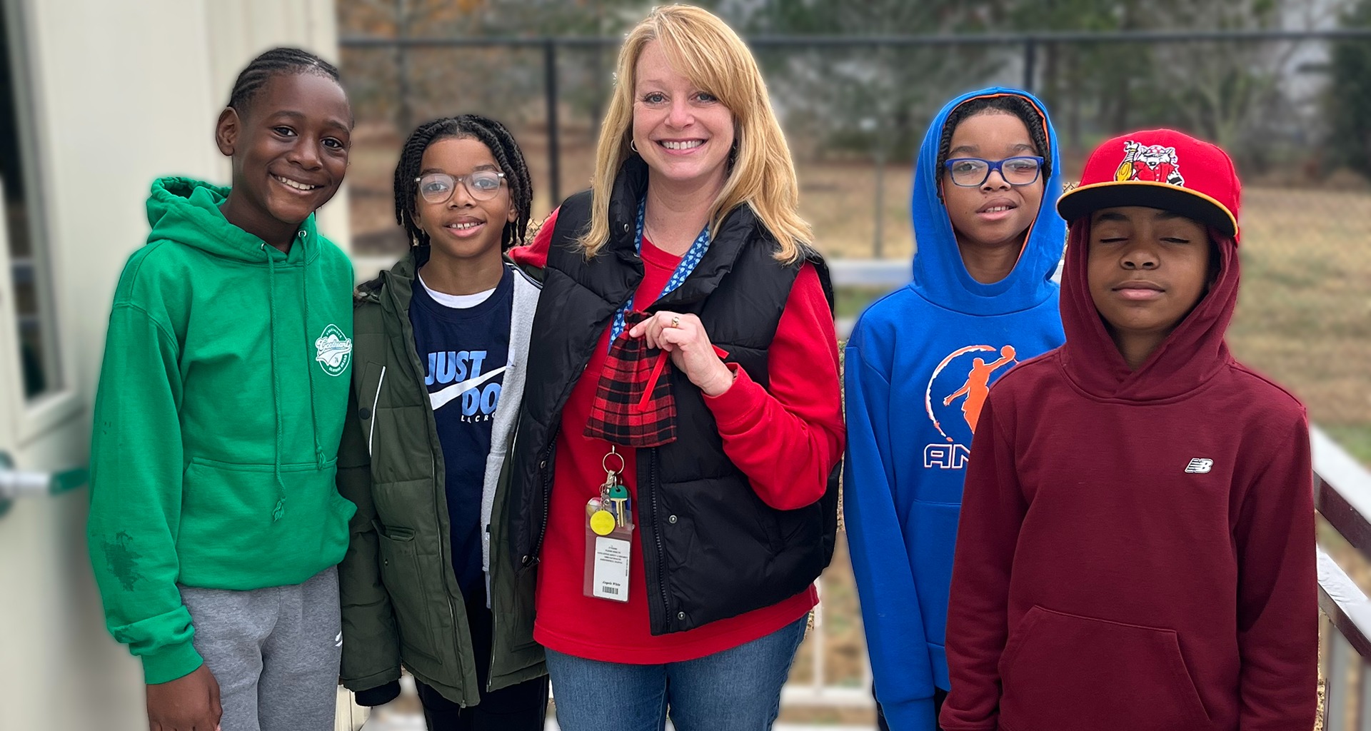 Teacher poses with four students