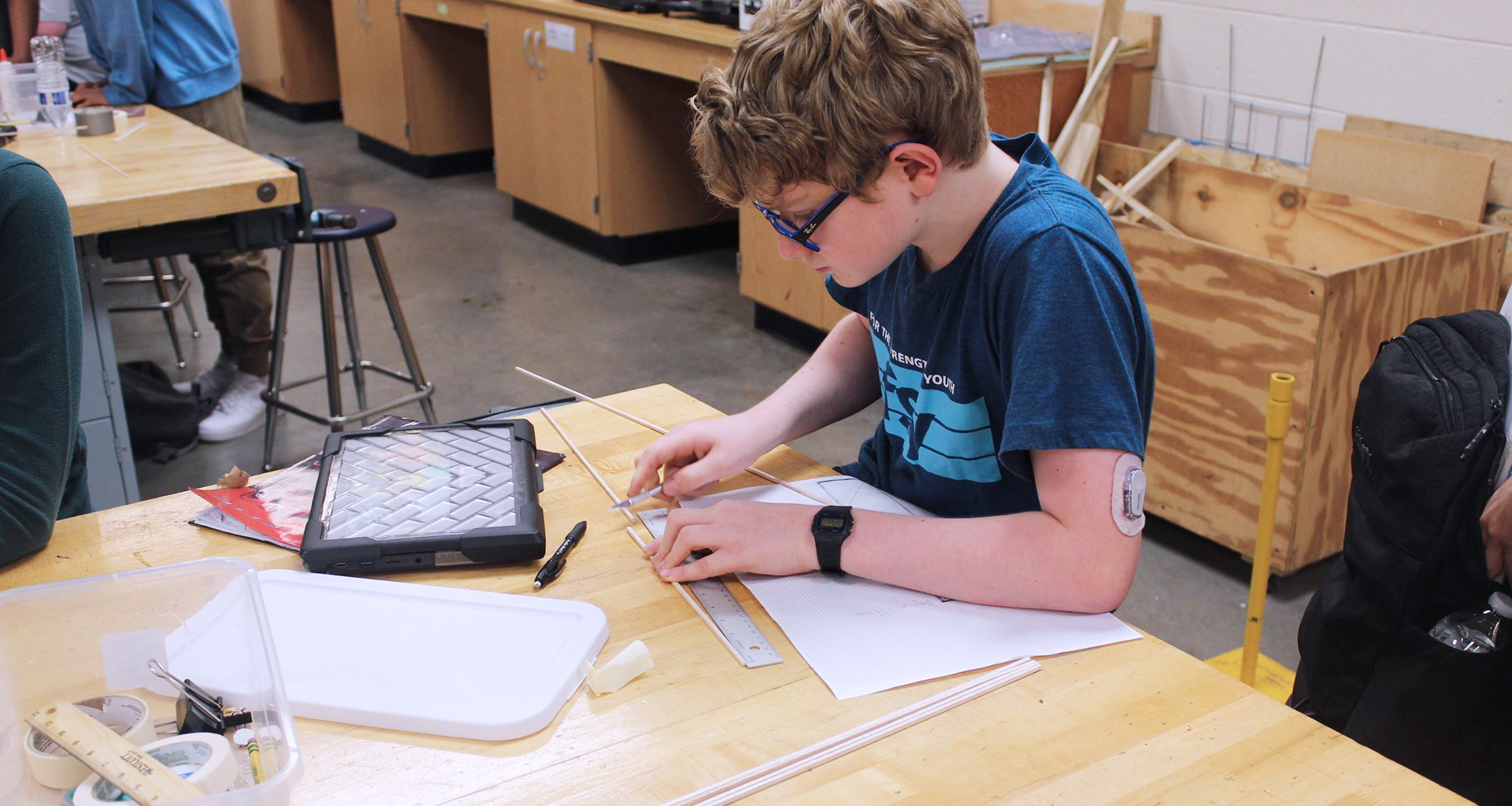 student working with a ruler at a desk.