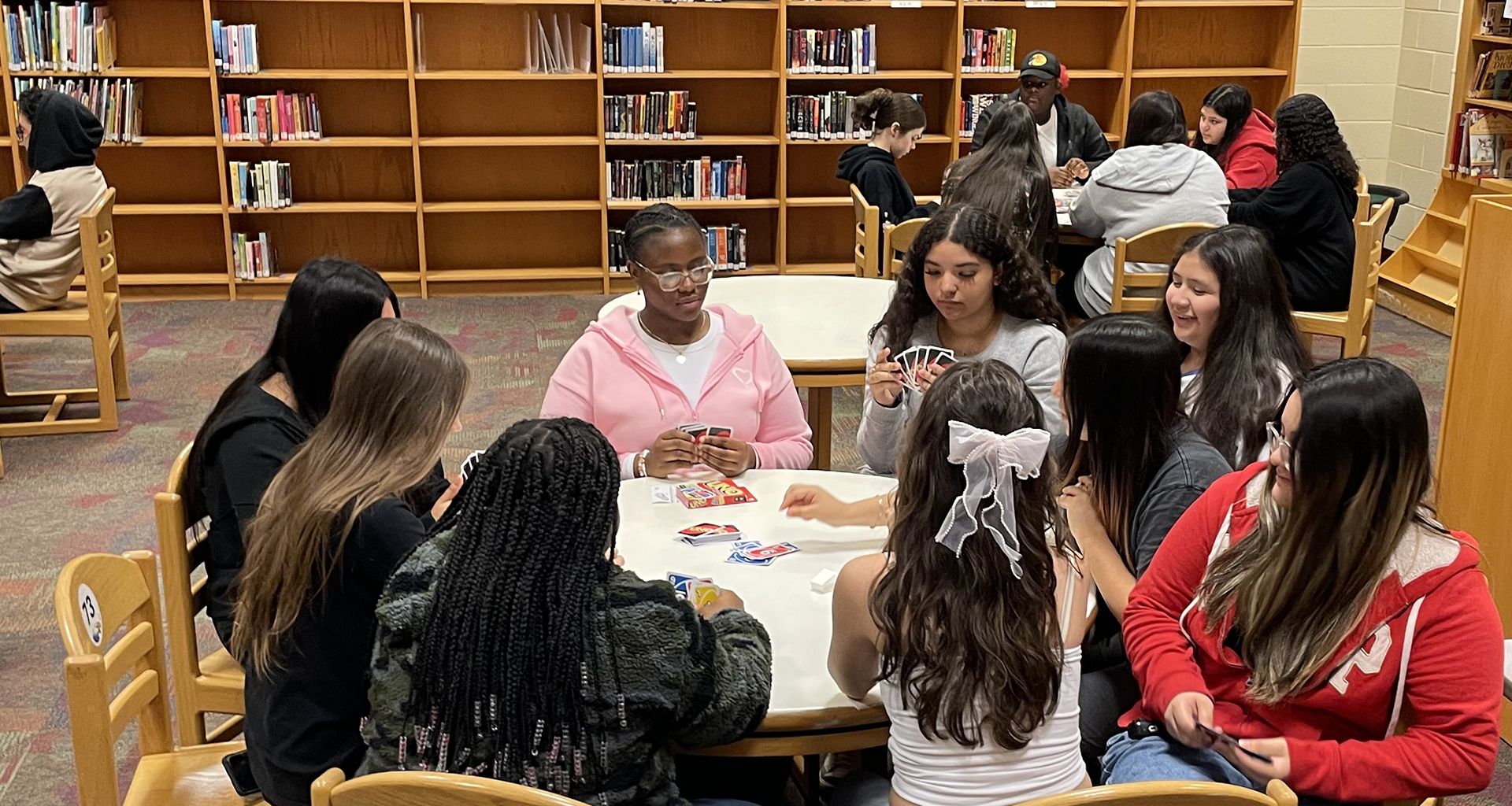 Students playing cards in library