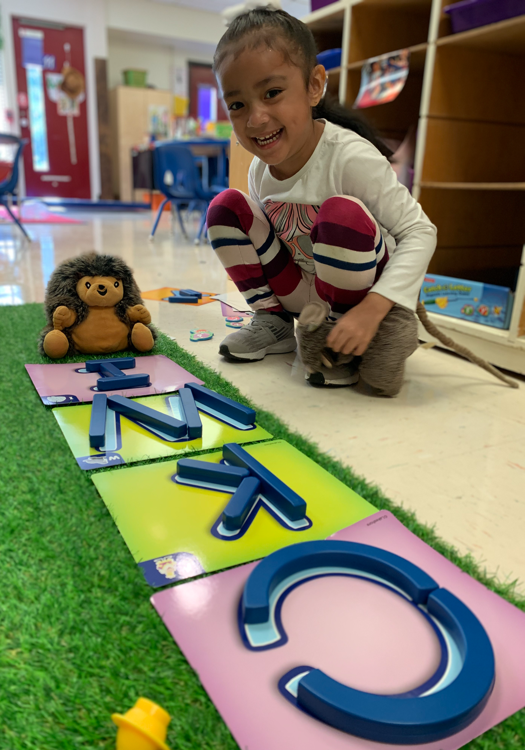 A girl playing with letter blocks in class