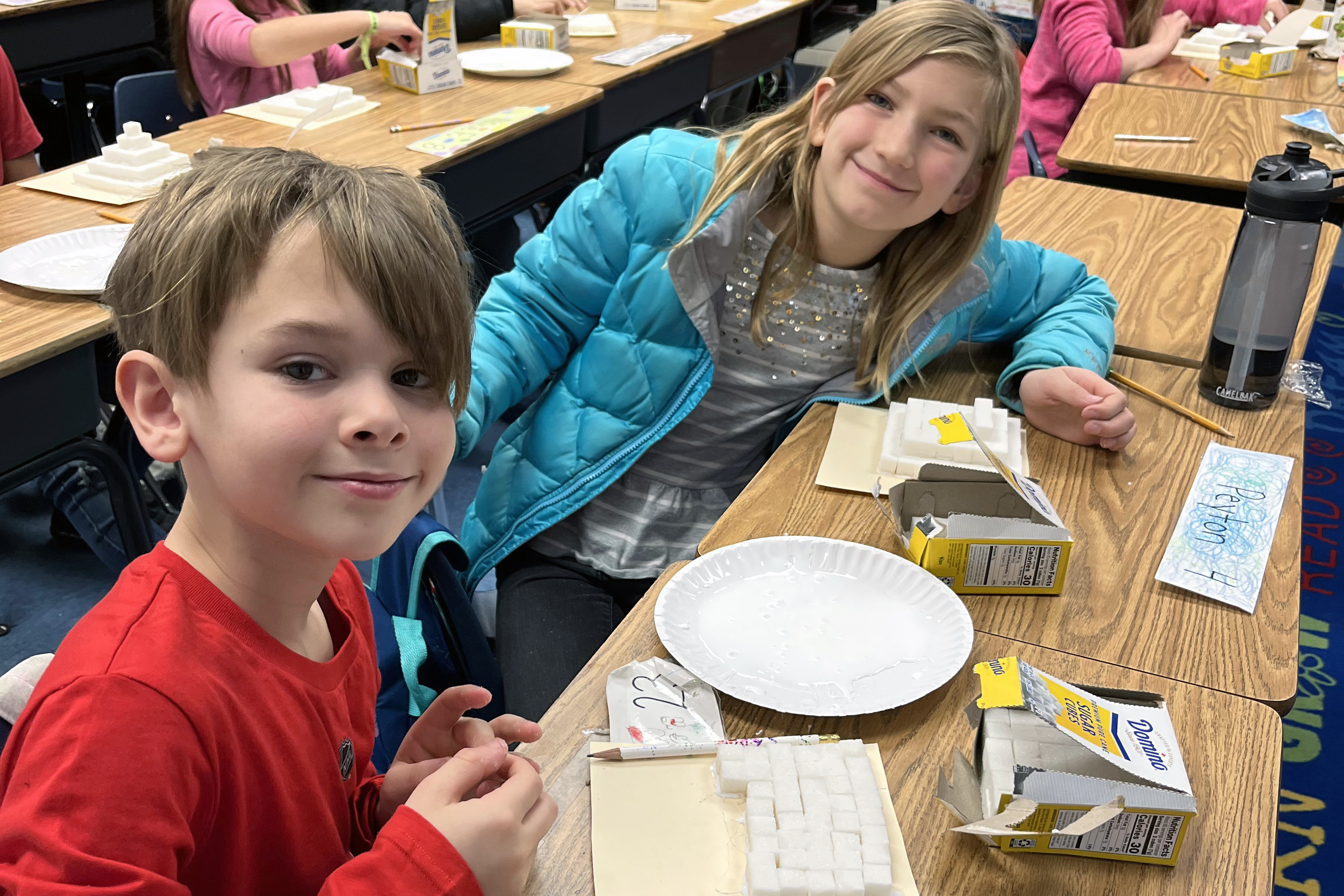 Two students working on a project with sugar