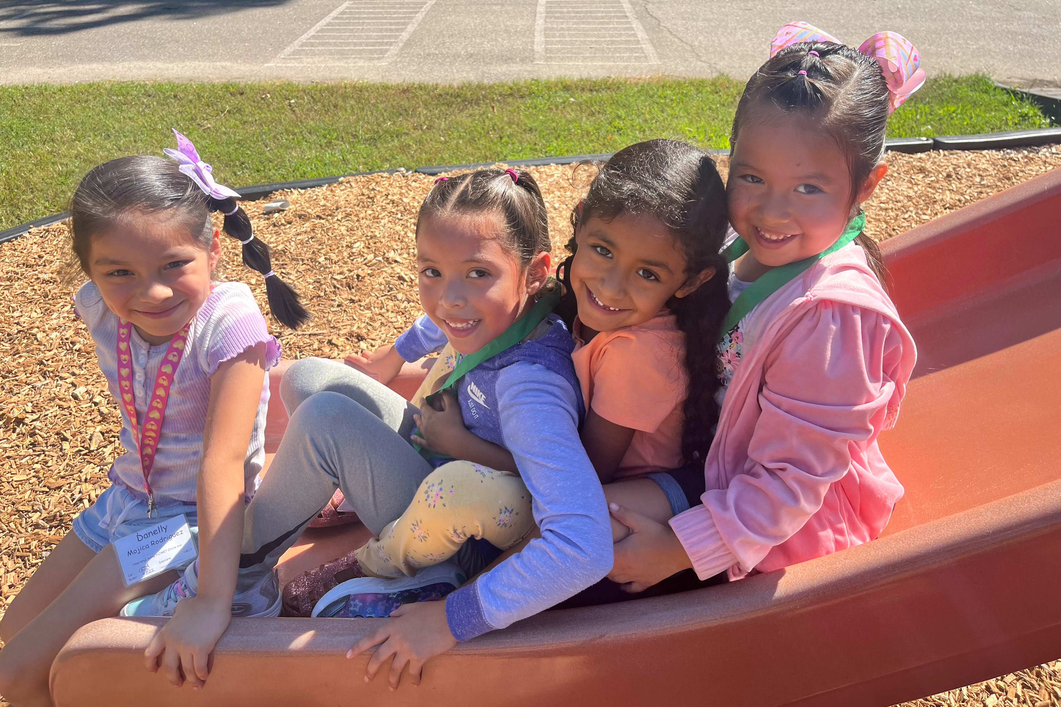 Four girls playing on the slide