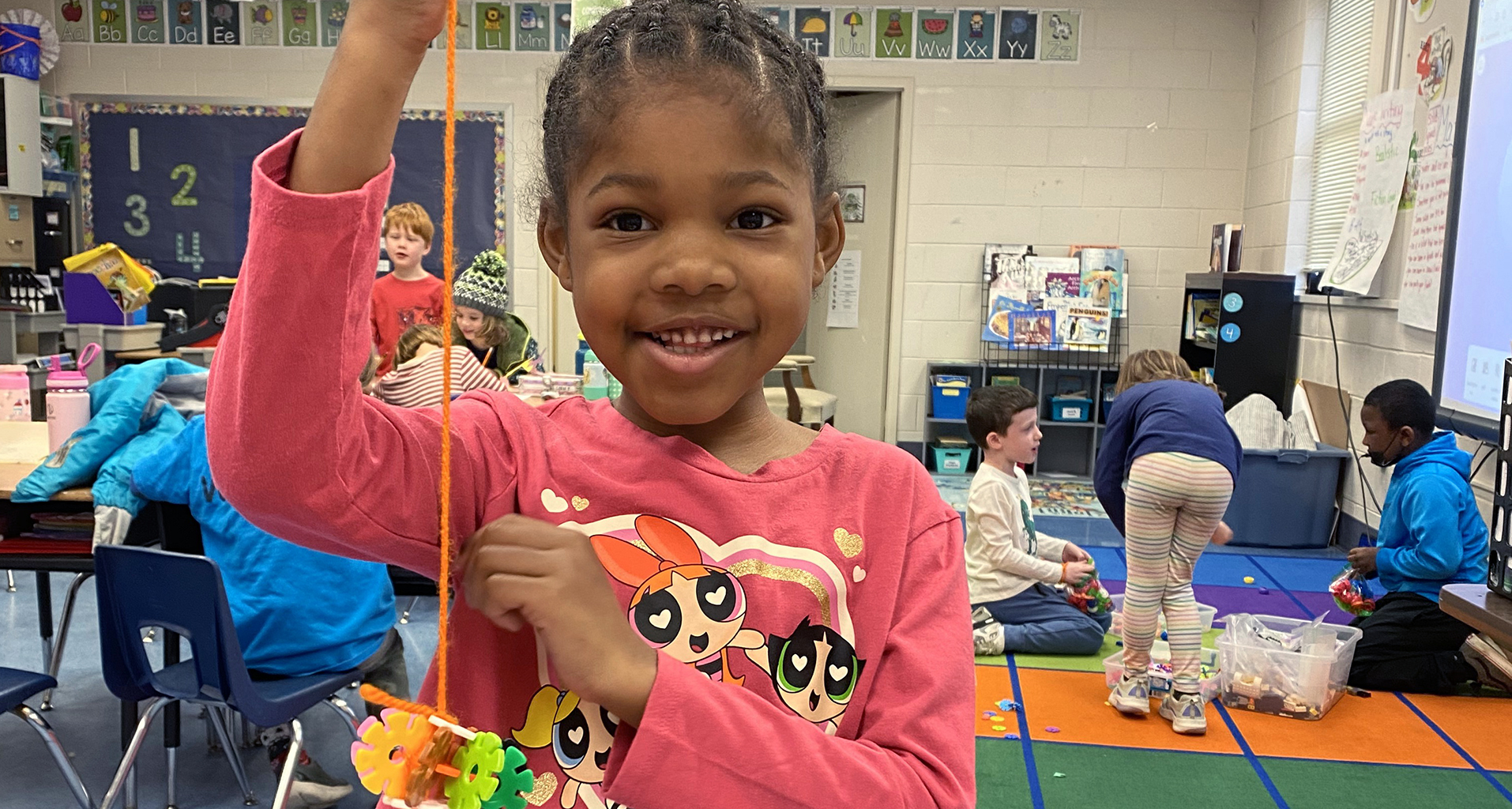 A girl holding up a project that she created