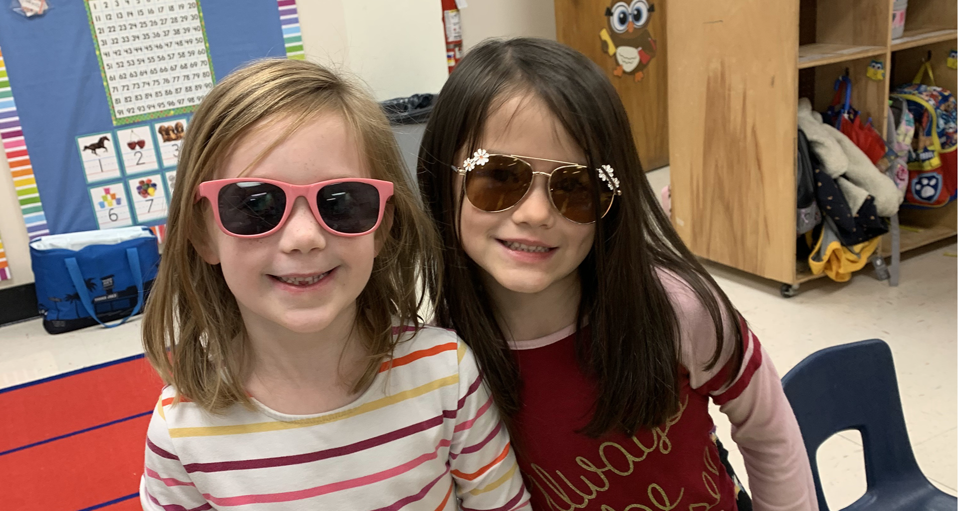 Two girls wearing sunglasses in class