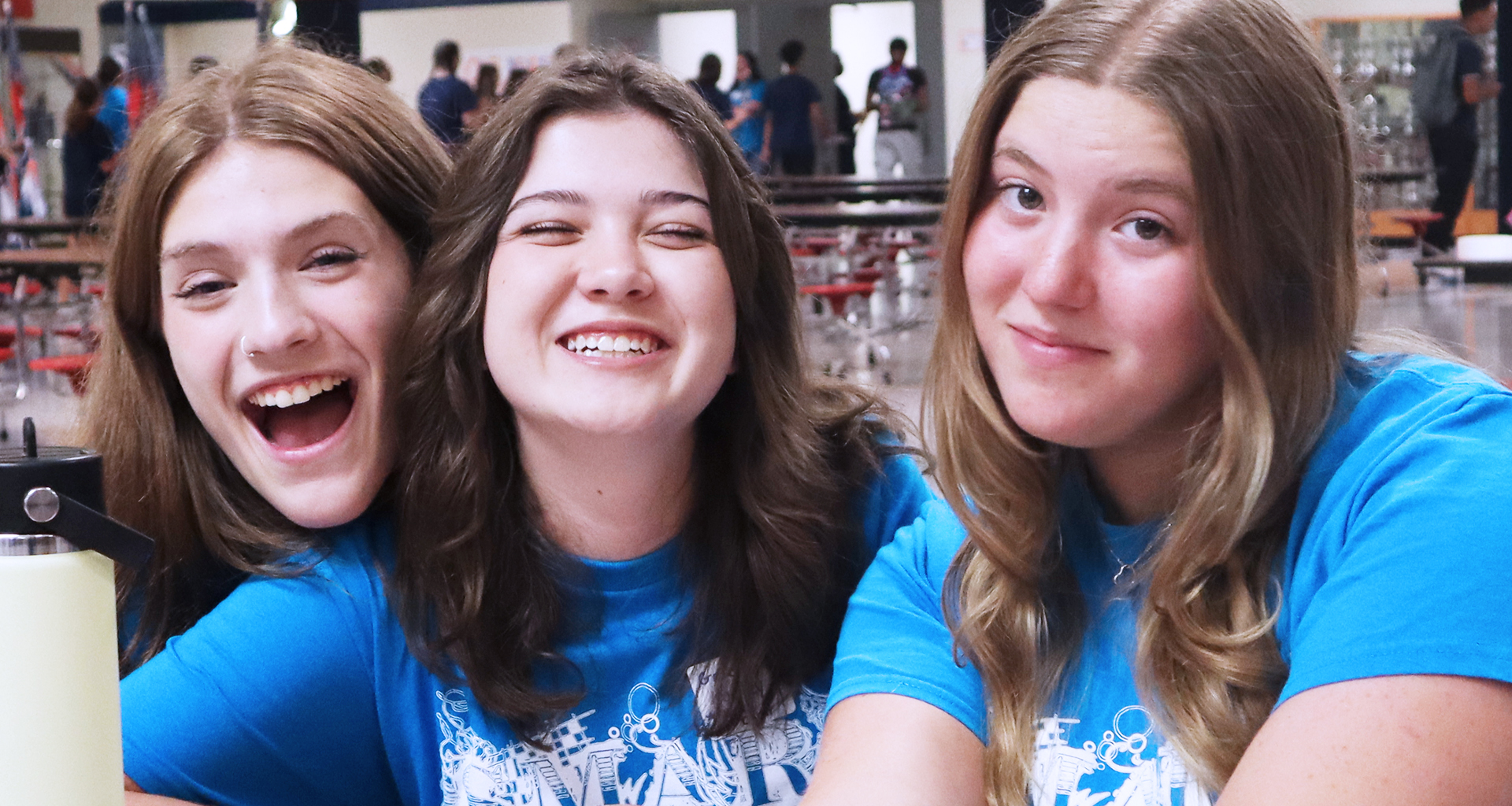 Three students smile for the camera
