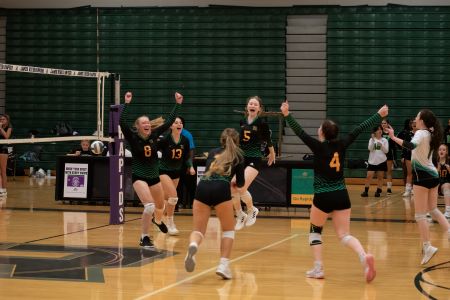 Girls volleyball team celebrating a play