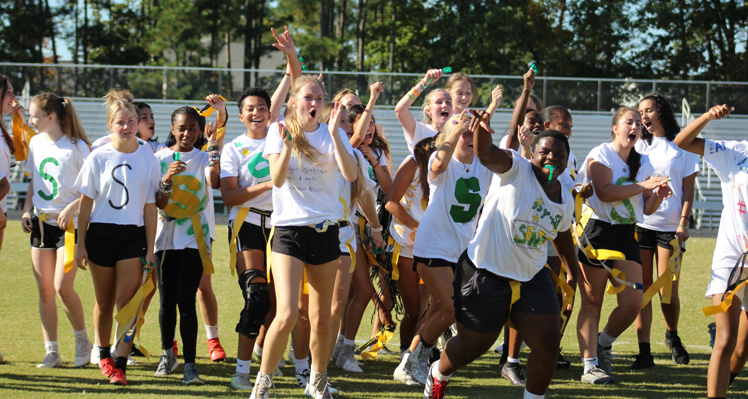 Girls celebrating on the field after winning a game of flag football