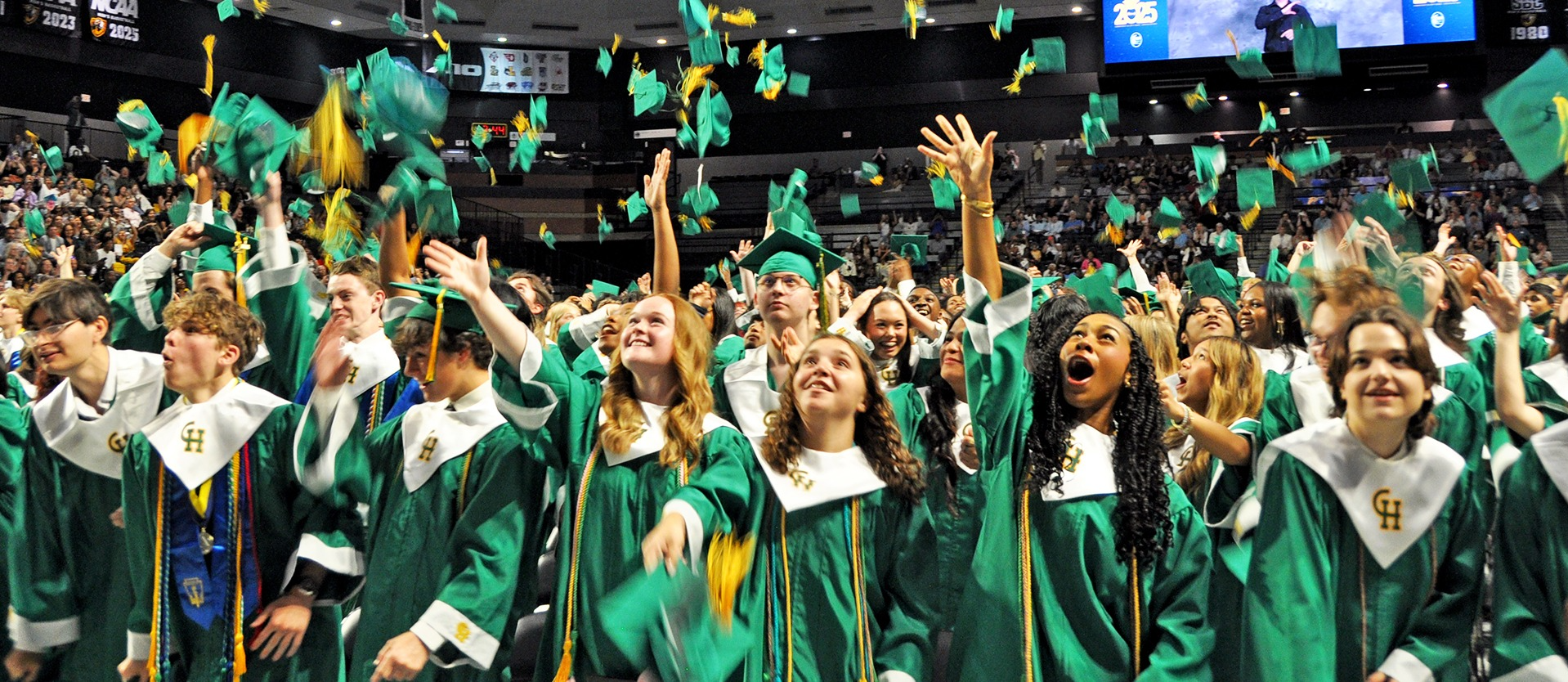 students tossing hats at graduation