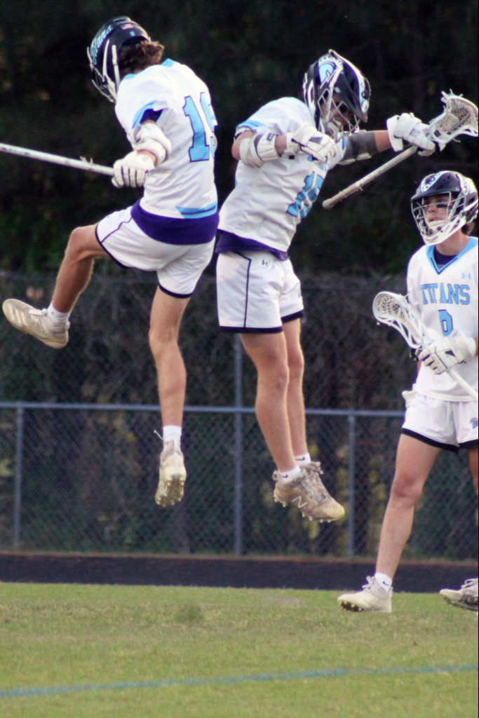 Two lacrosse players jumping in the air