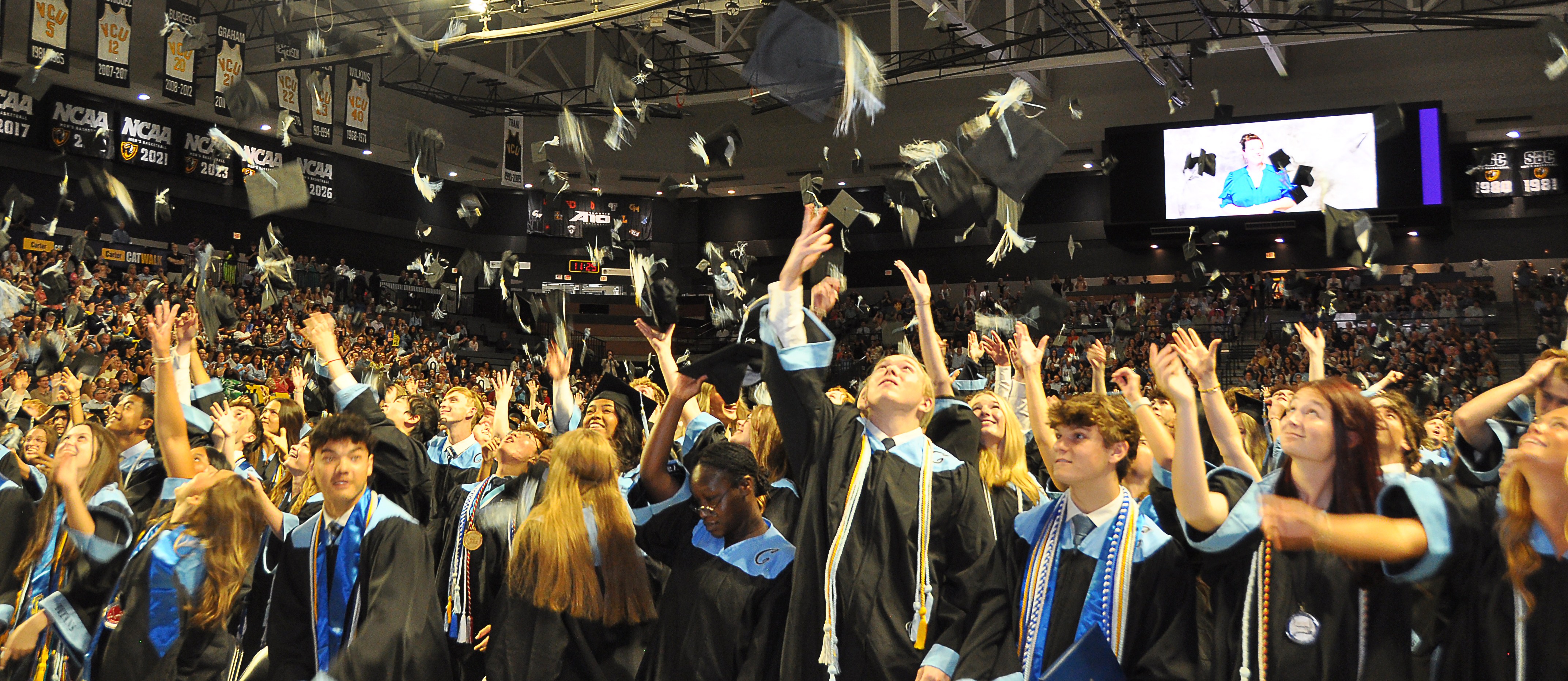 grads tossing hats in the air at graduation