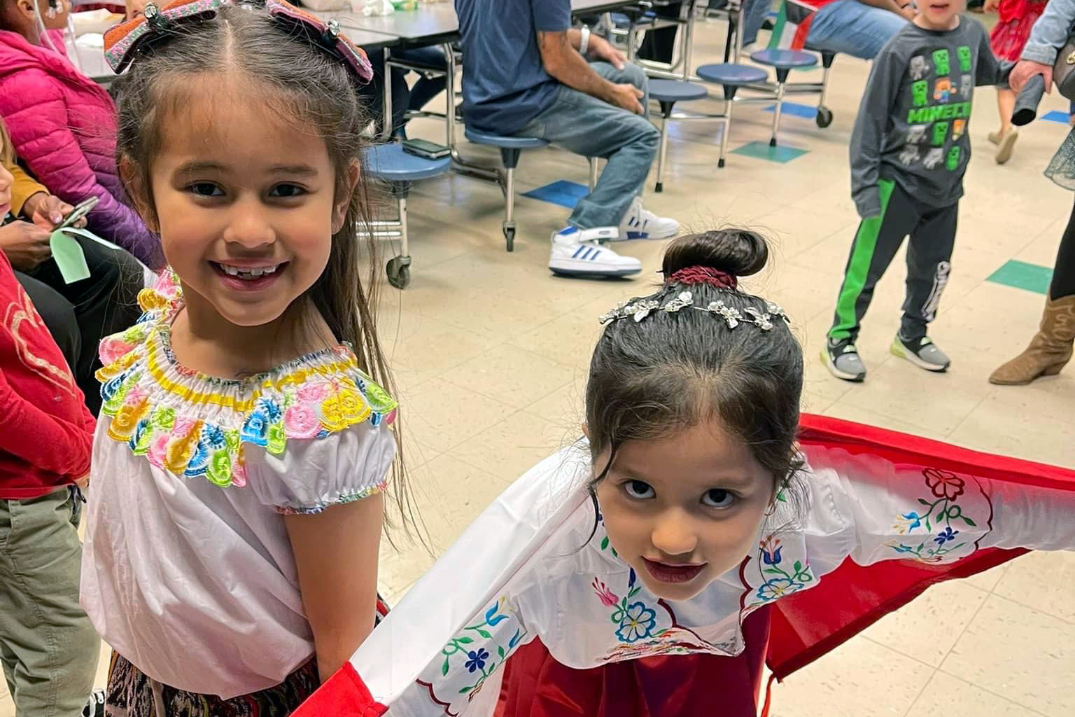 Two young girls dressed in cultural outfits.