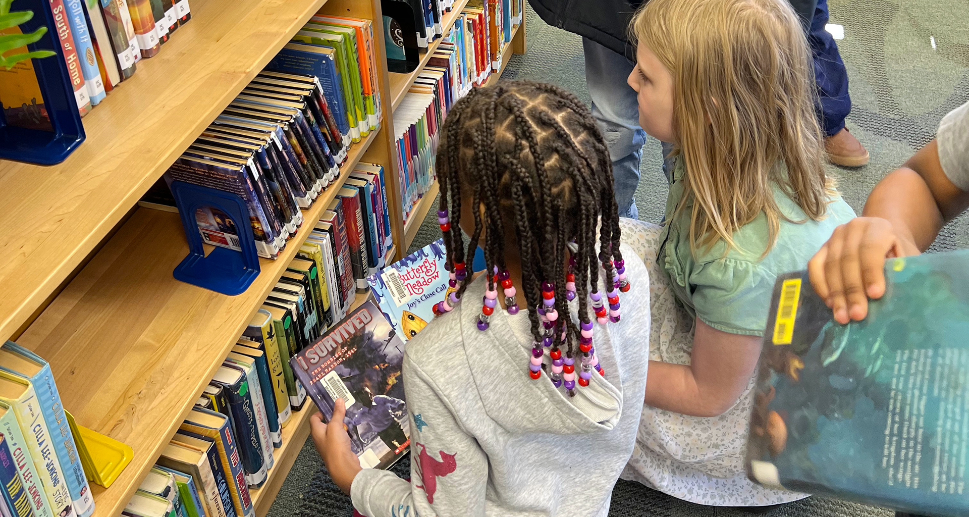 Two student selecting a book from the vending machine.