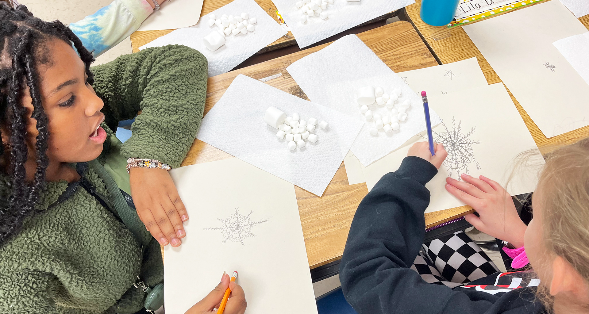 Two females working on snowflake designs