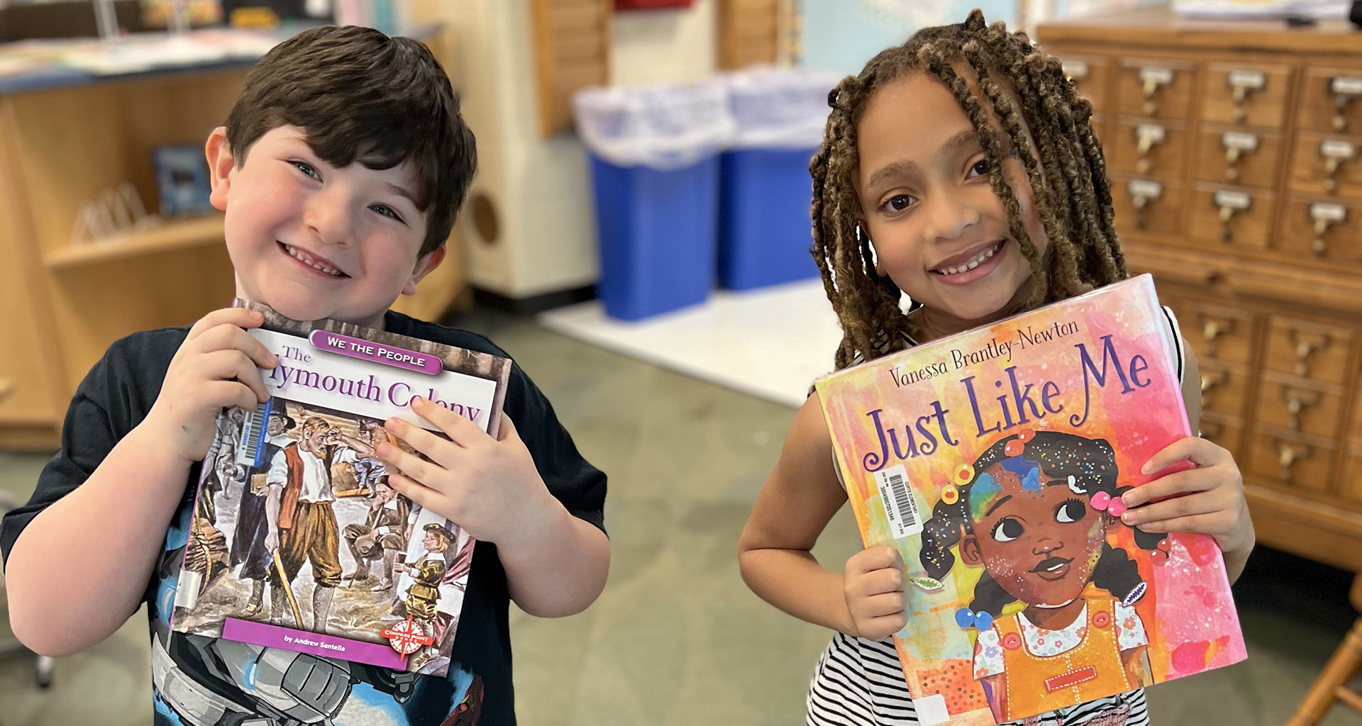 students showing off their new books