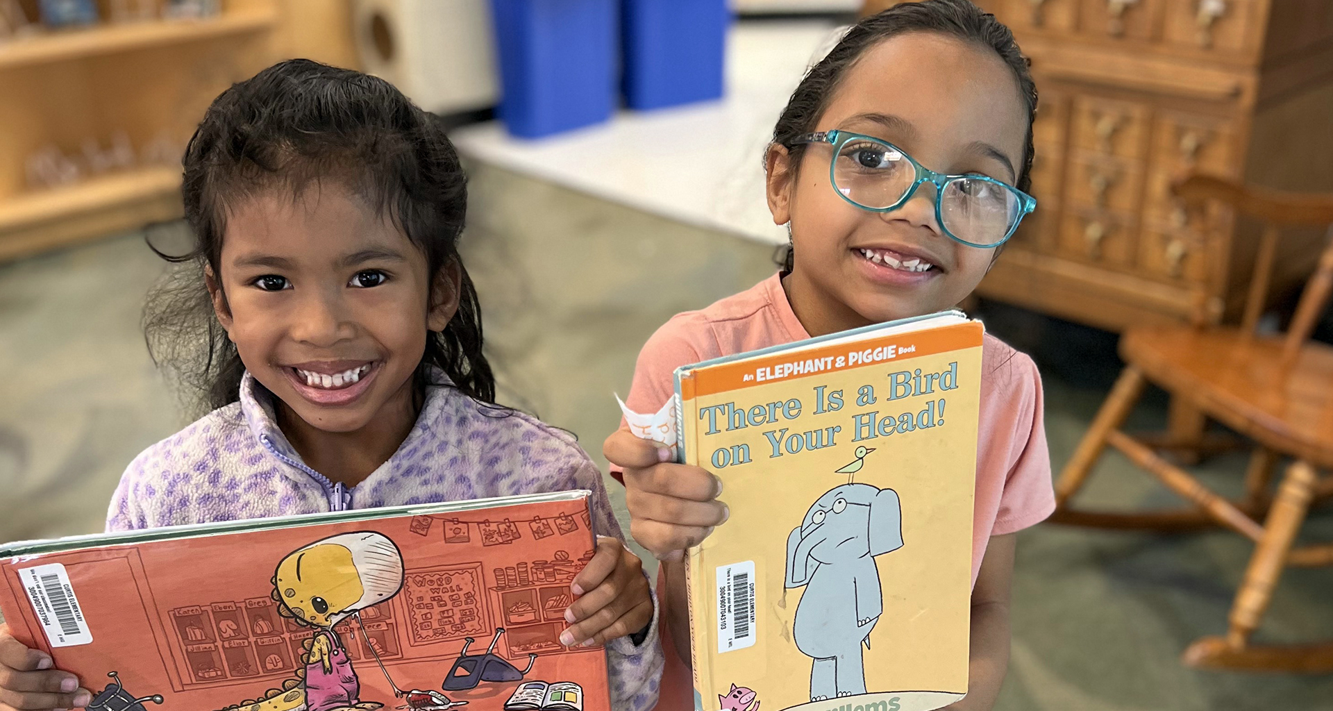 Two students hold up their book selection