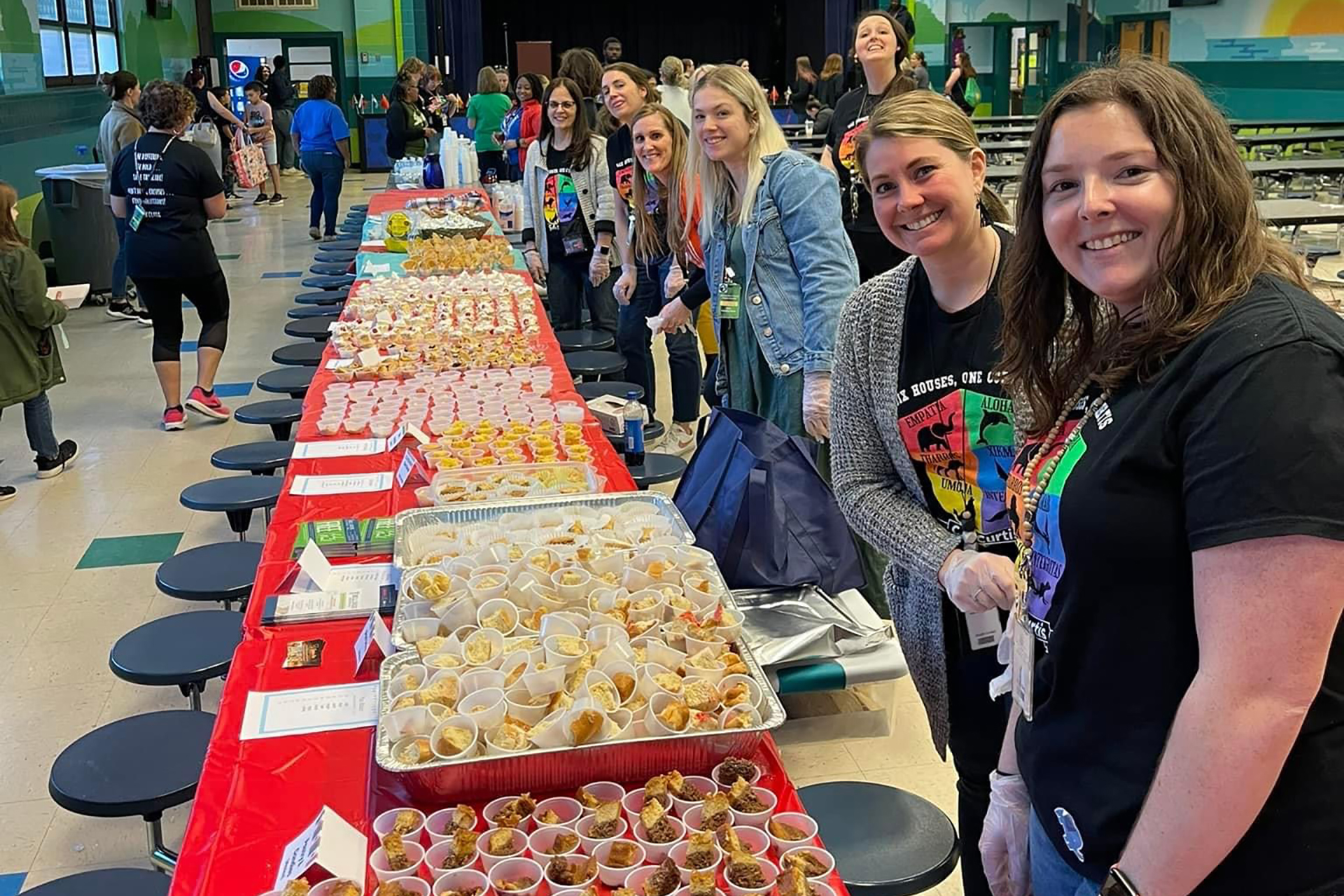 Parents lined up against table of food they made.