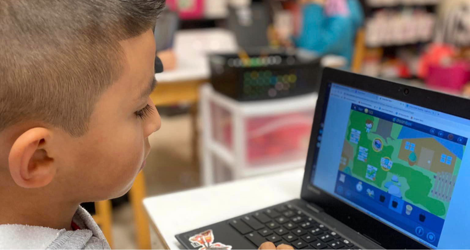 A boy working on his laptop in class