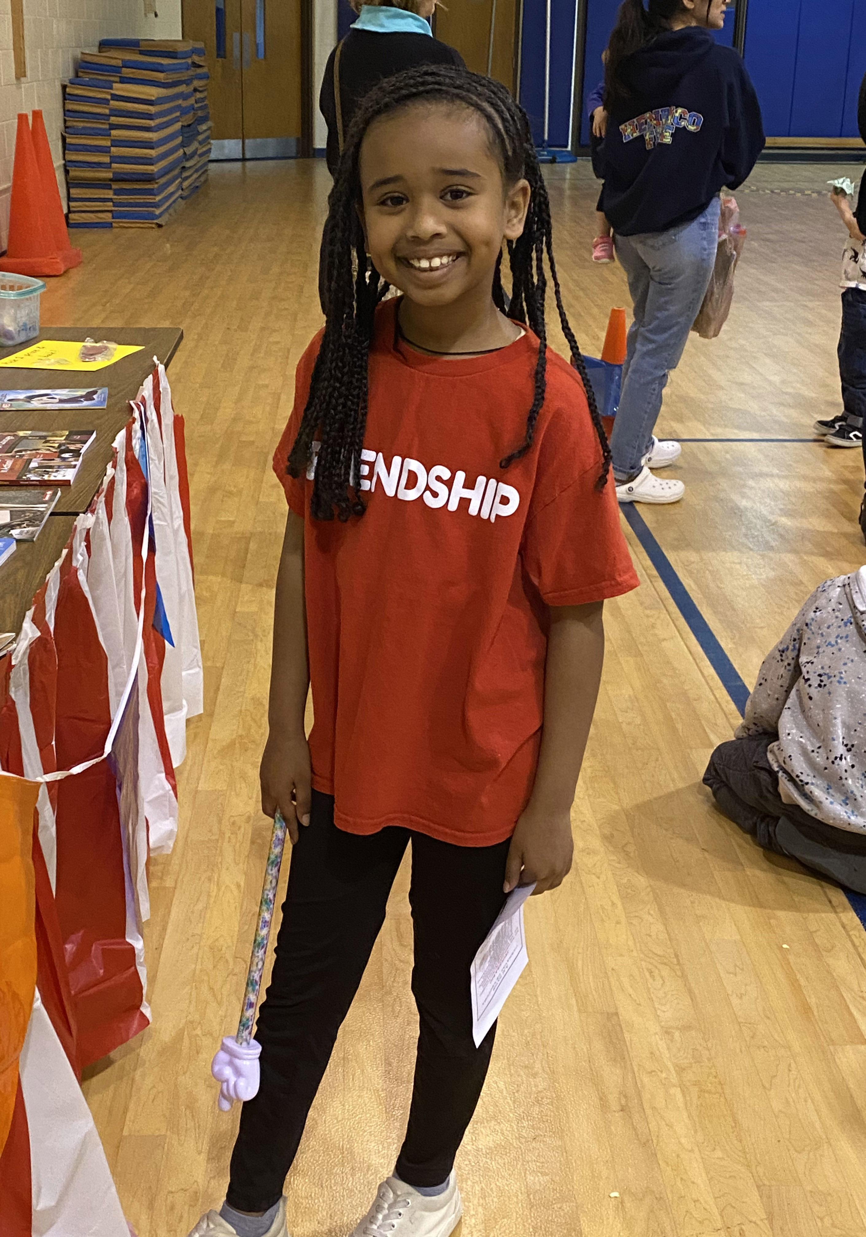 A girl poses for a photo in the school gymnasium