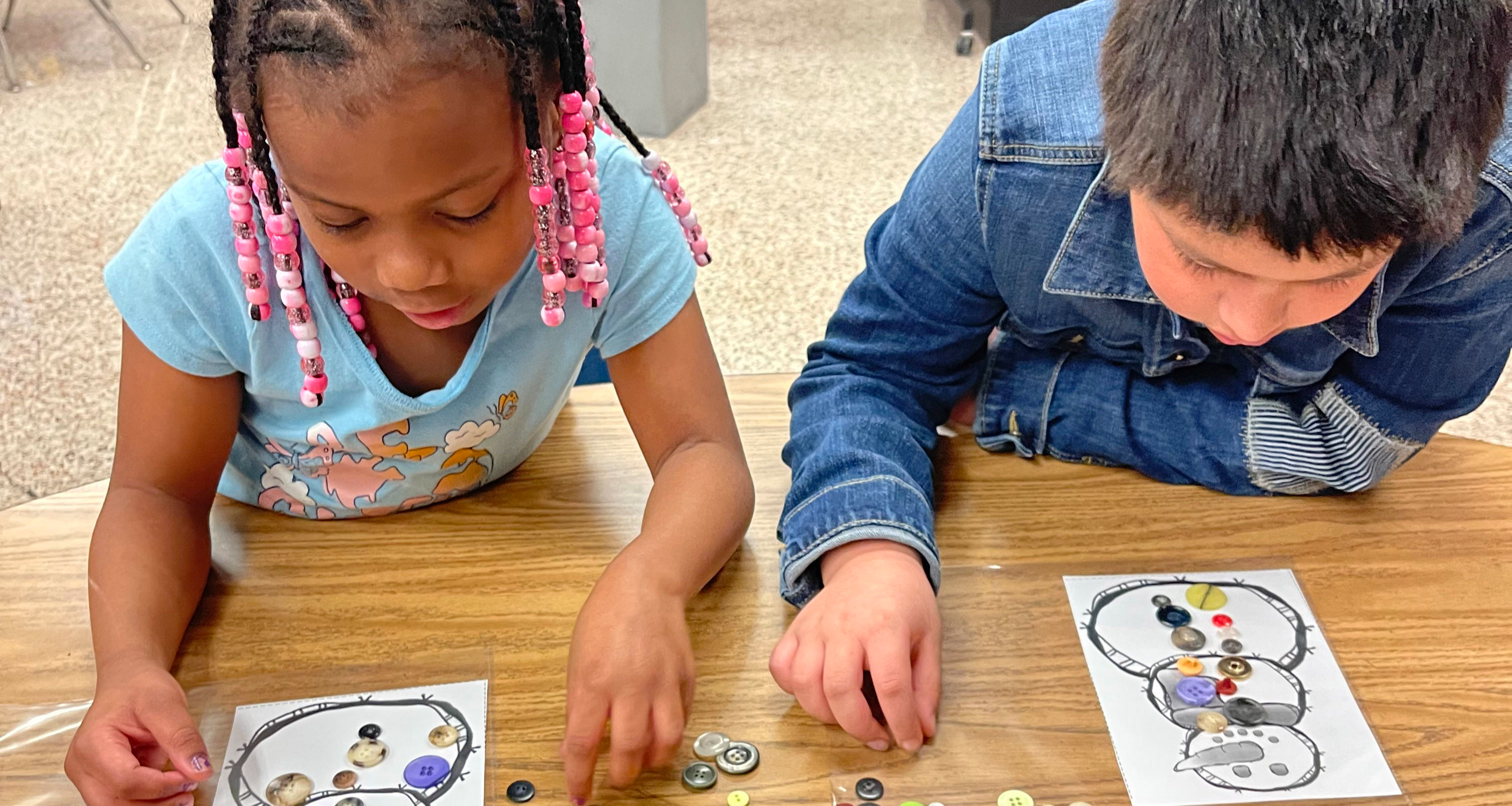 Two students working with buttons on an assignment