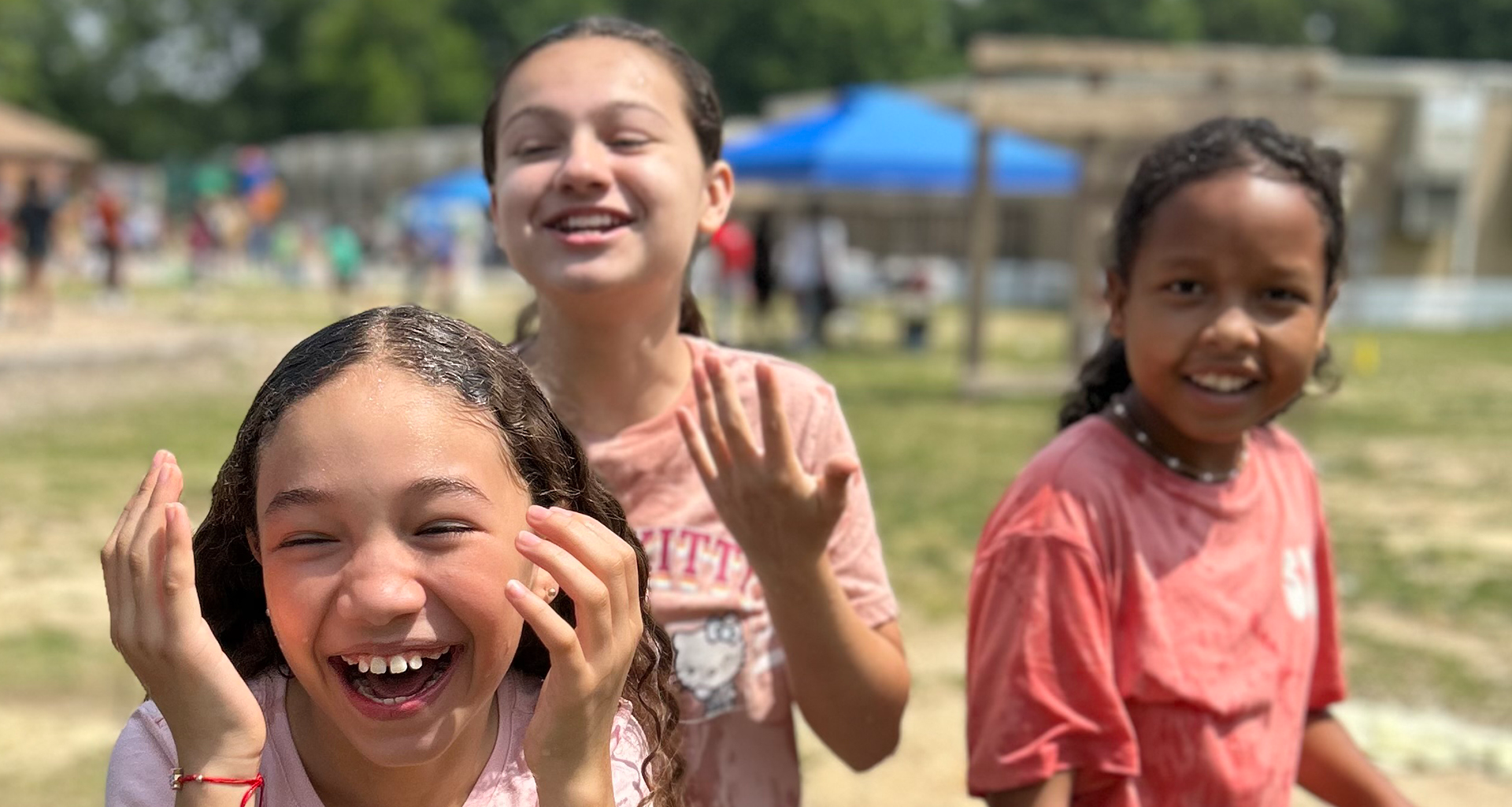 Three students laughing outside during field day