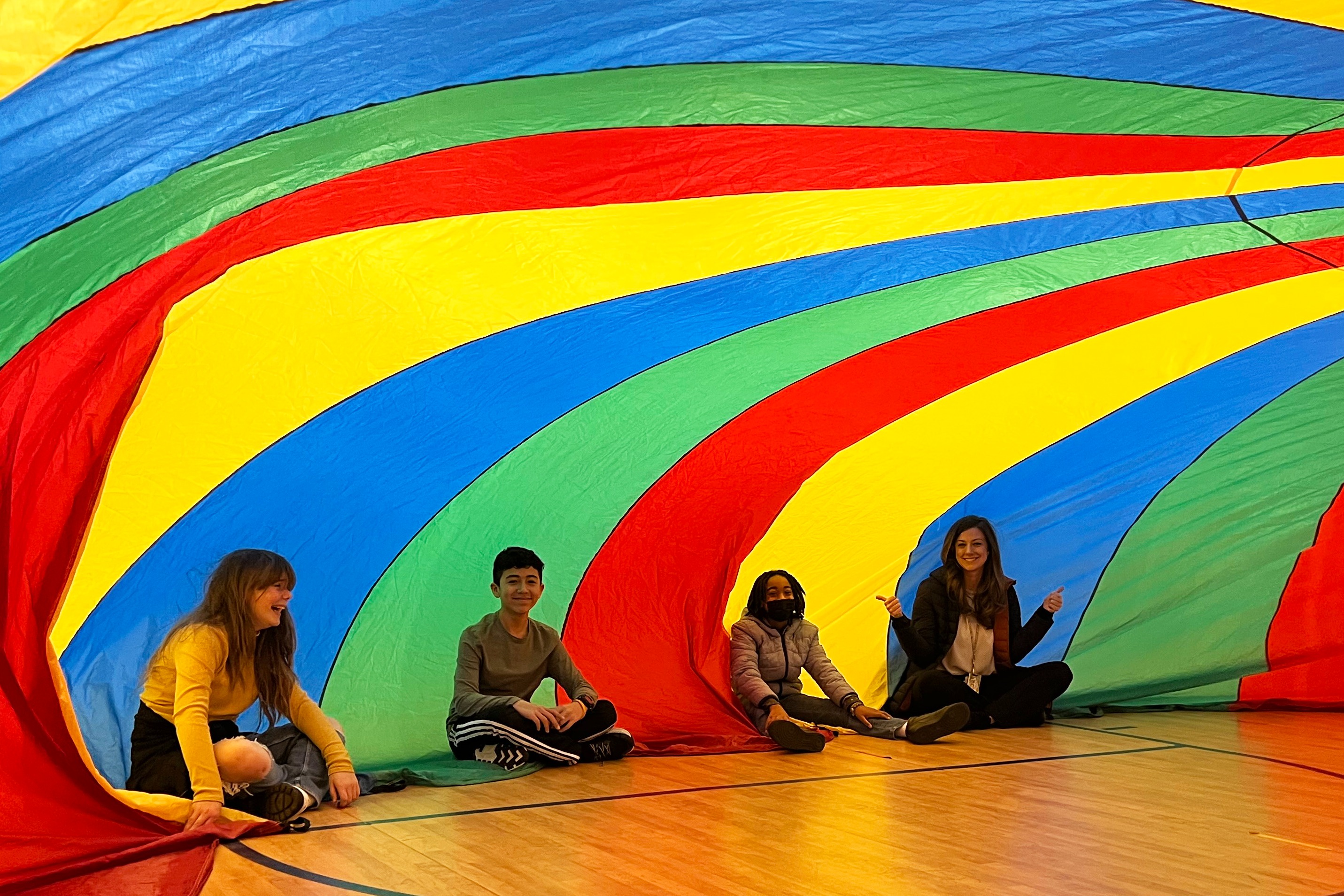 A group of under a big rainbow tent