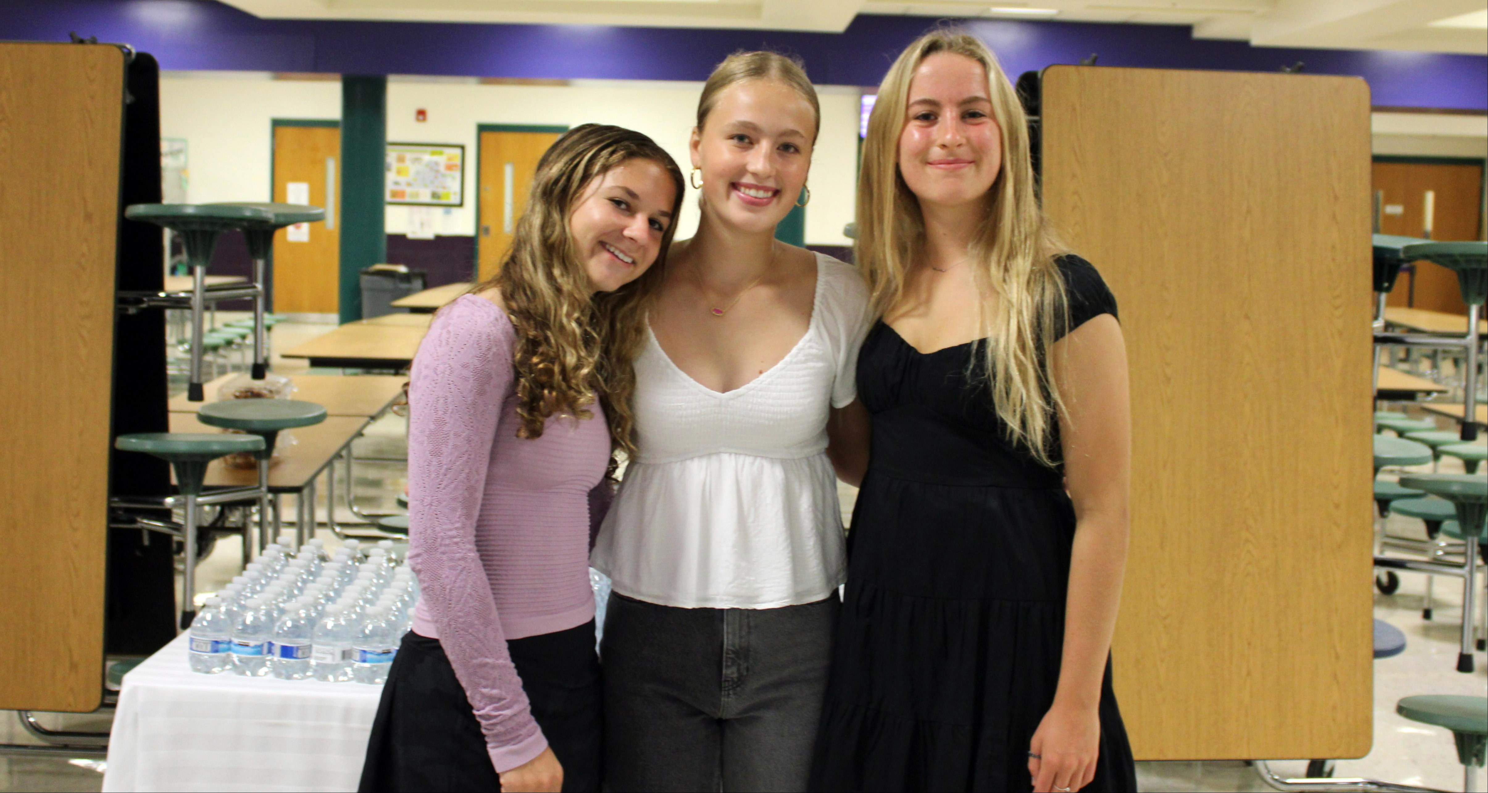 Three girls smiling in the school cafeteria