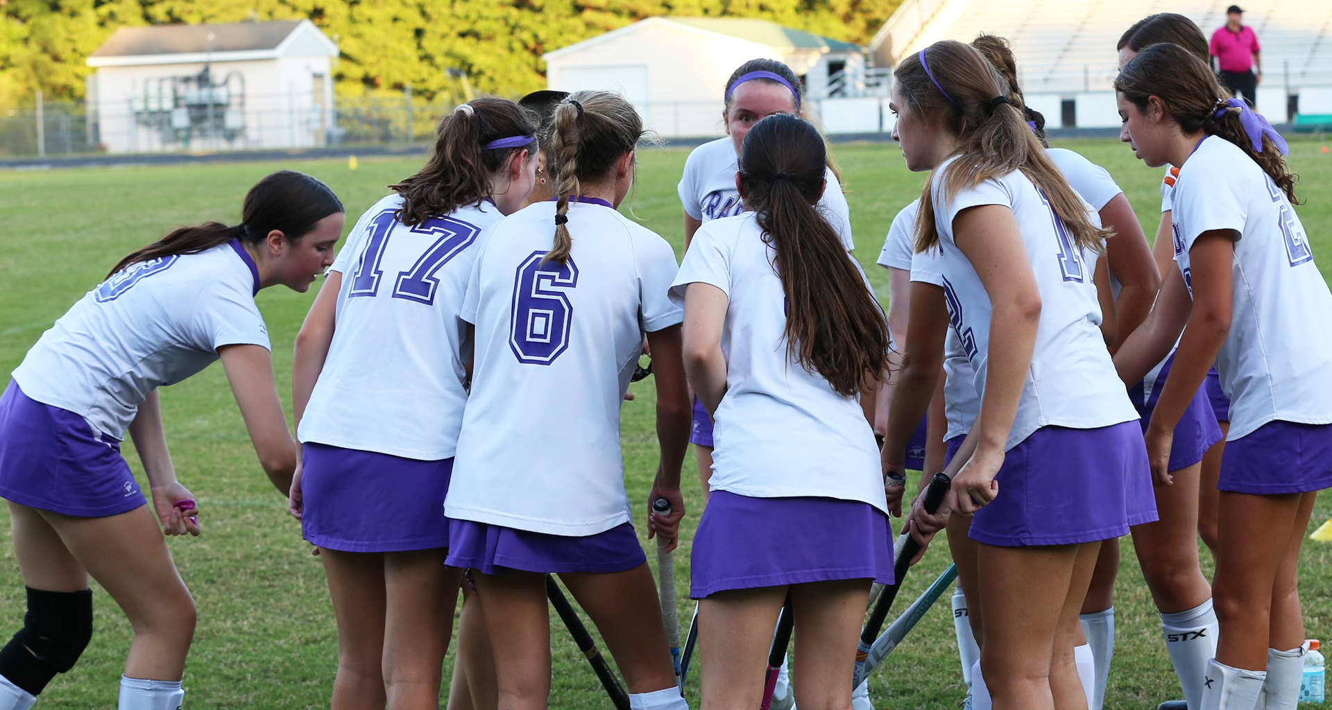 Girls on Lacrosse team in a huddle