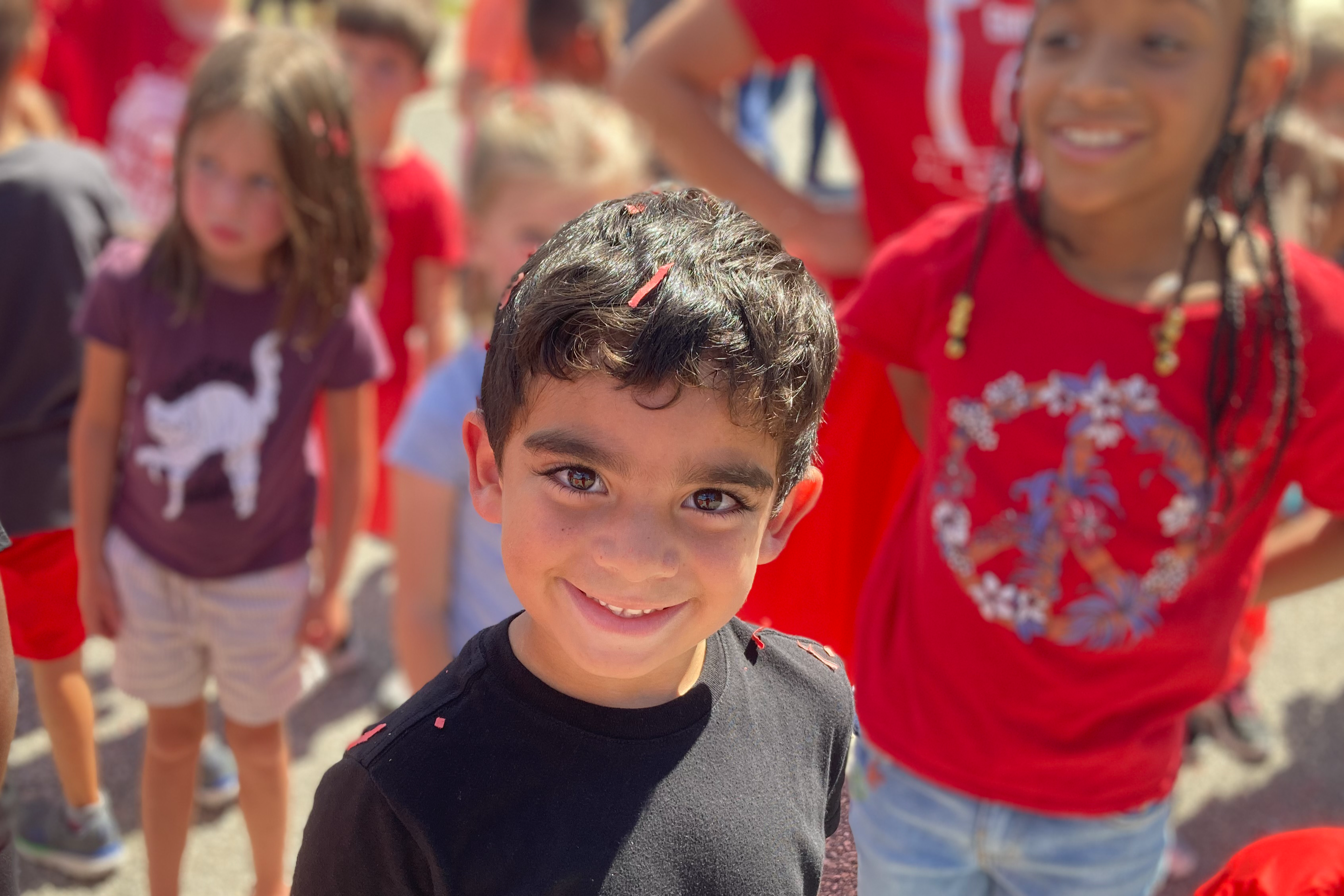 Young male standing in a group of students smiling for the camera.
