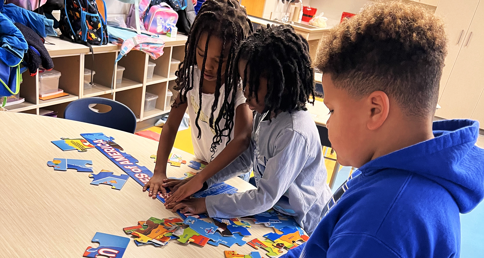 Three students building a puzzle in the classroom