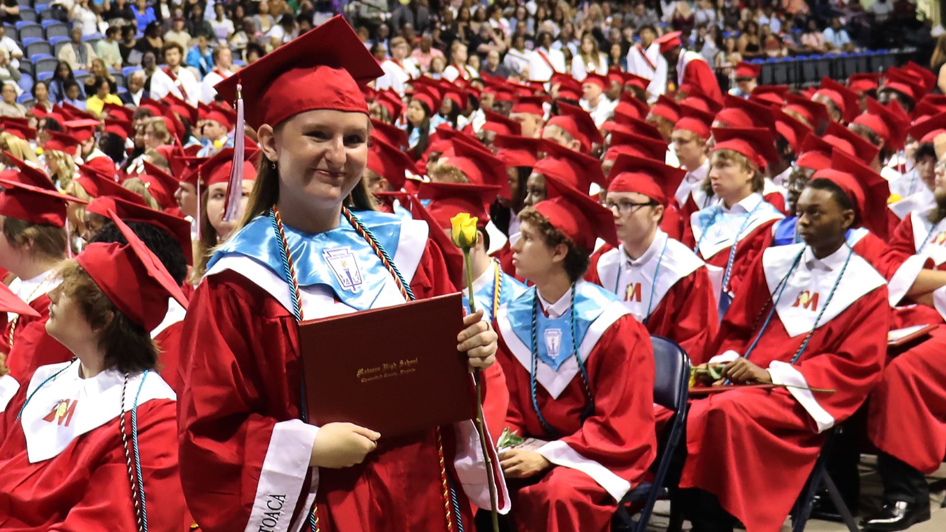 Graduate holding diploma and smiling