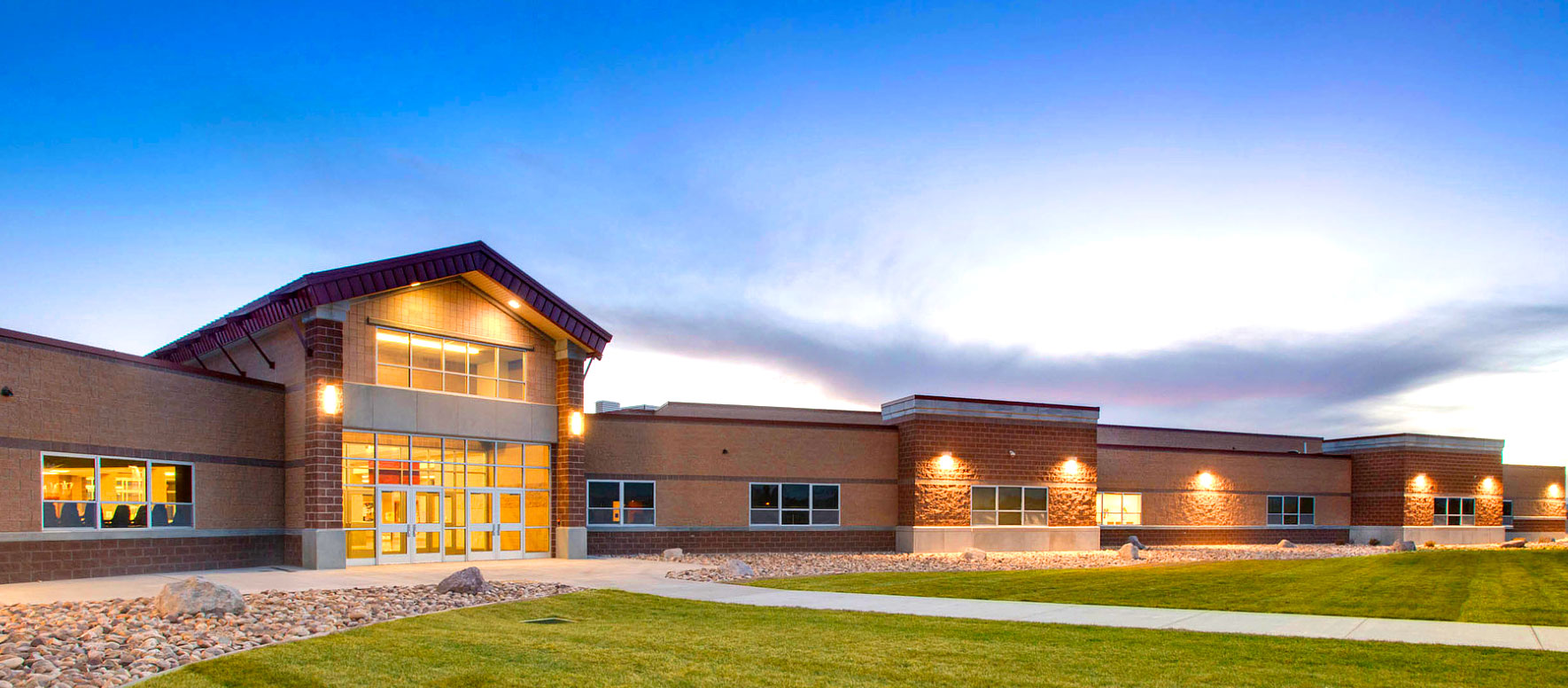 altamont high school at dusk with lights on front entry way