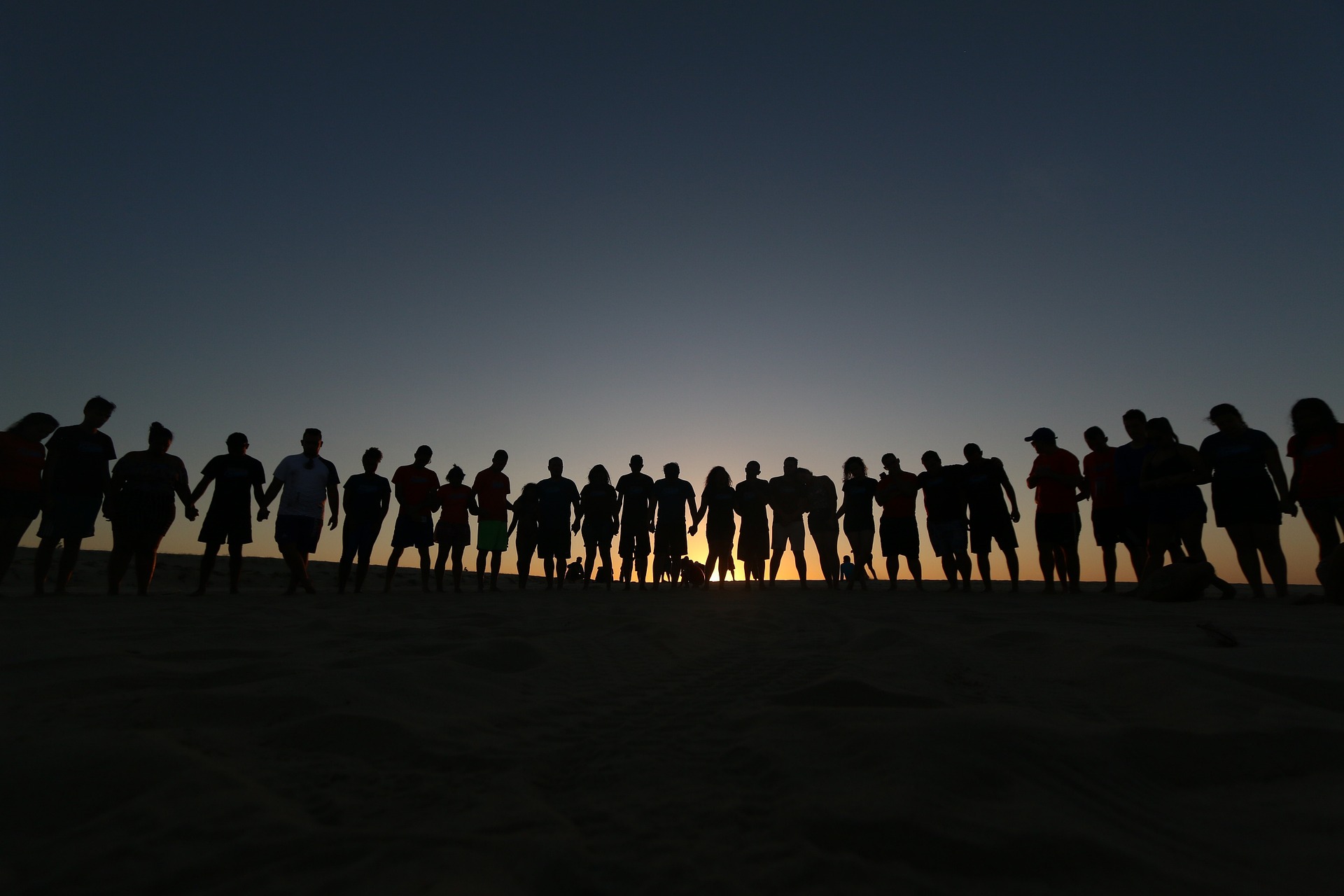 group of people standing at sunset