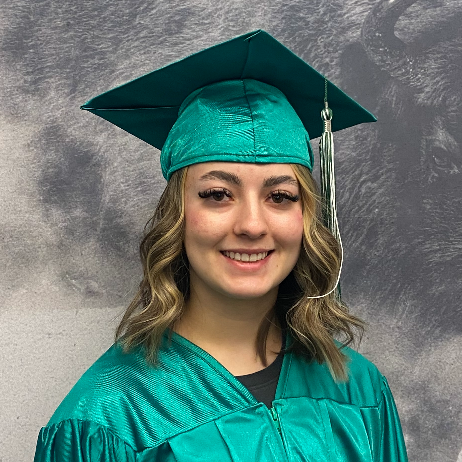 Kalee Labrum in green graduation robes and cap