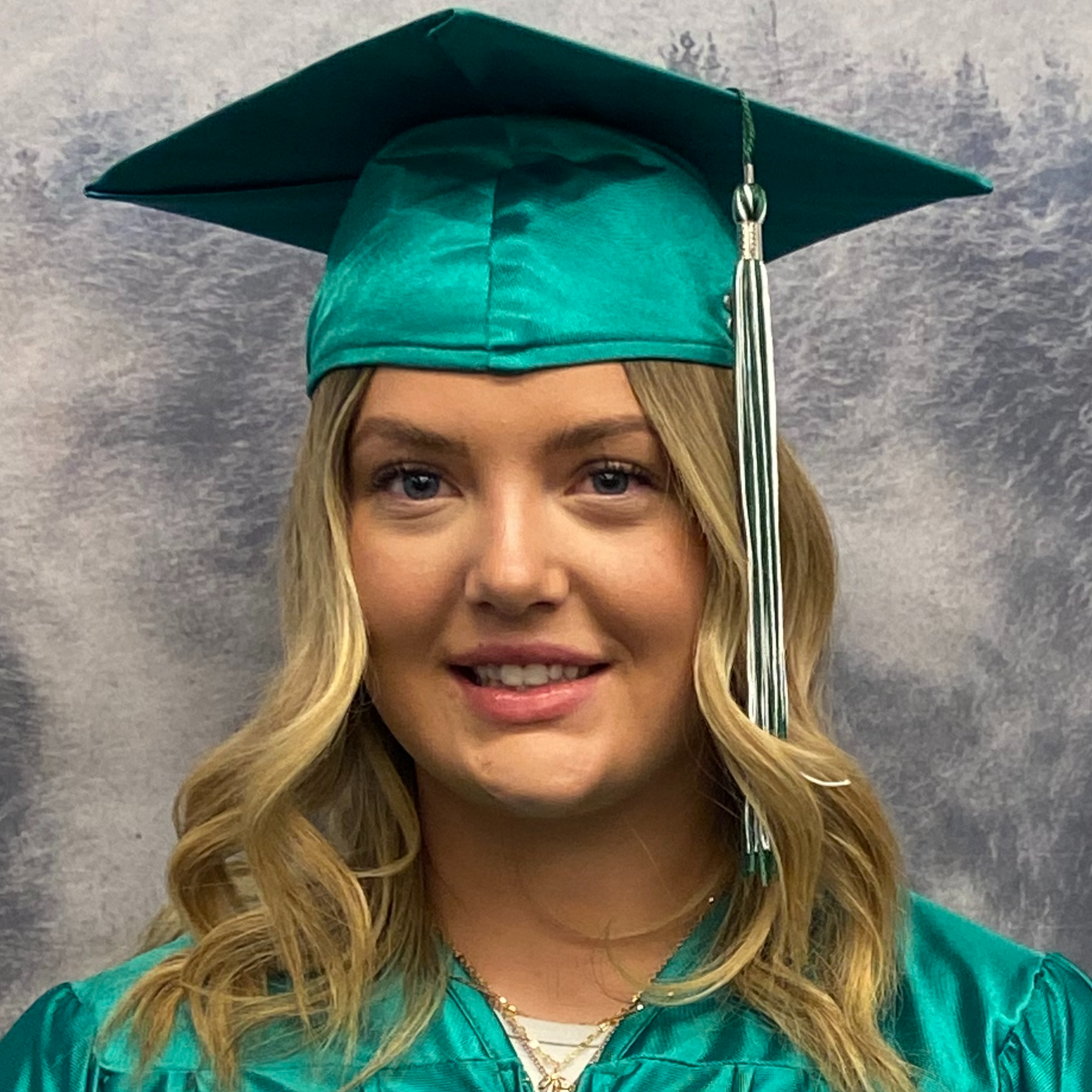 Brynna Smith in green graduation robes and cap