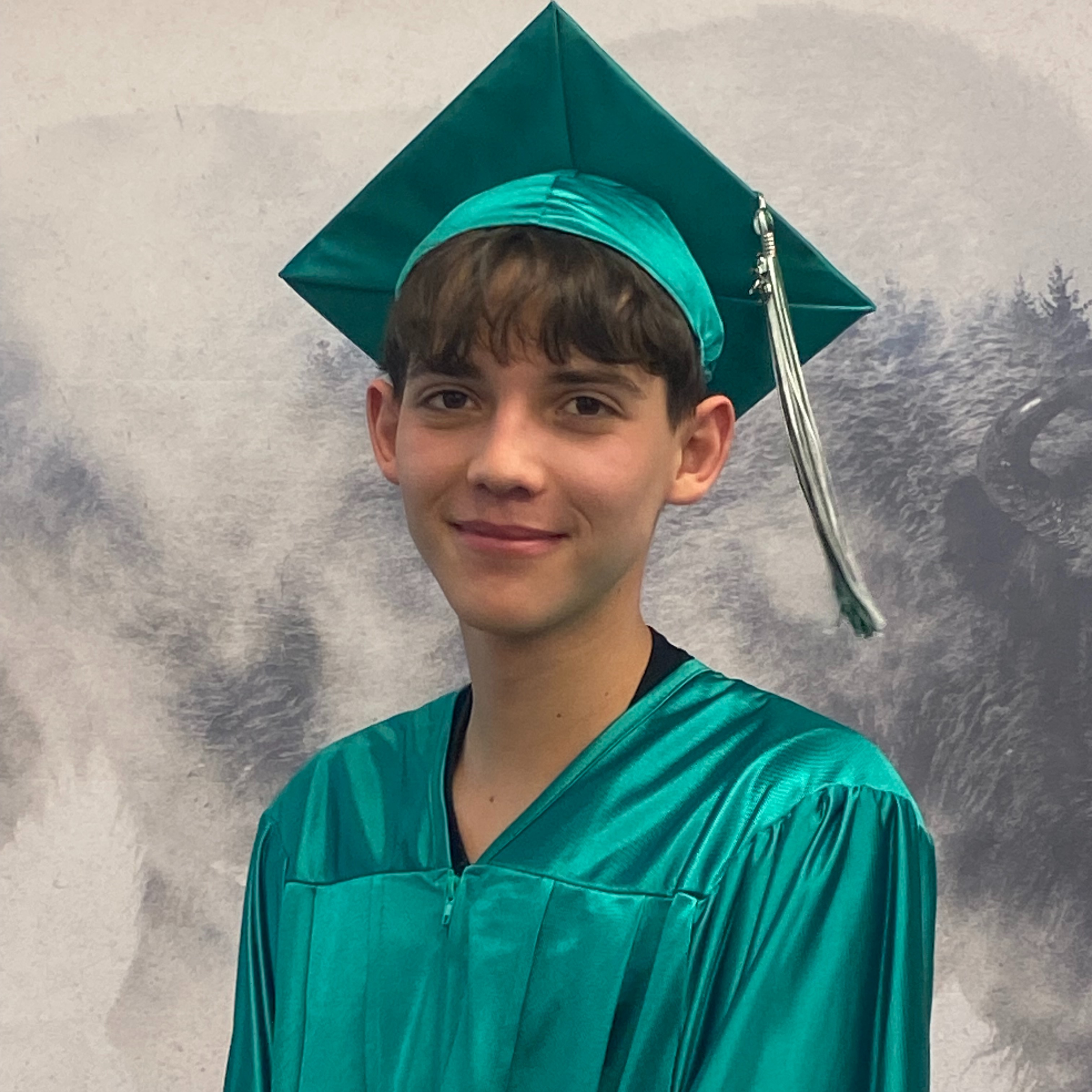 Tyrell Davis in green graduation robes and cap