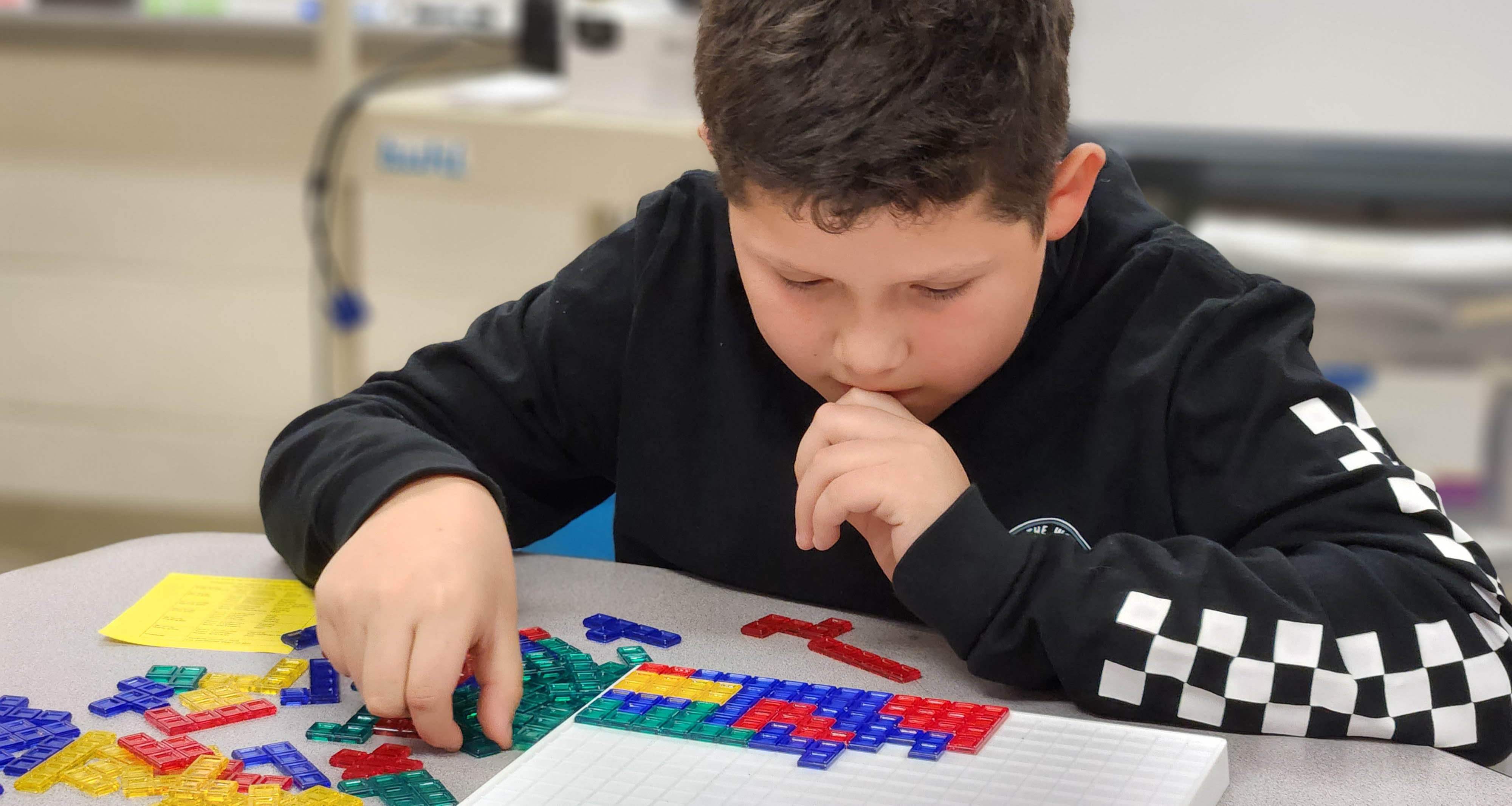 A student focused in class while put shapes in a specific position