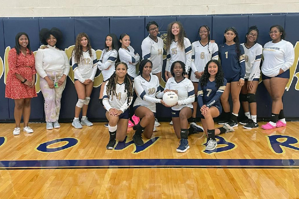 Girls' volleyball team poses for a group photo in the school gymnasium