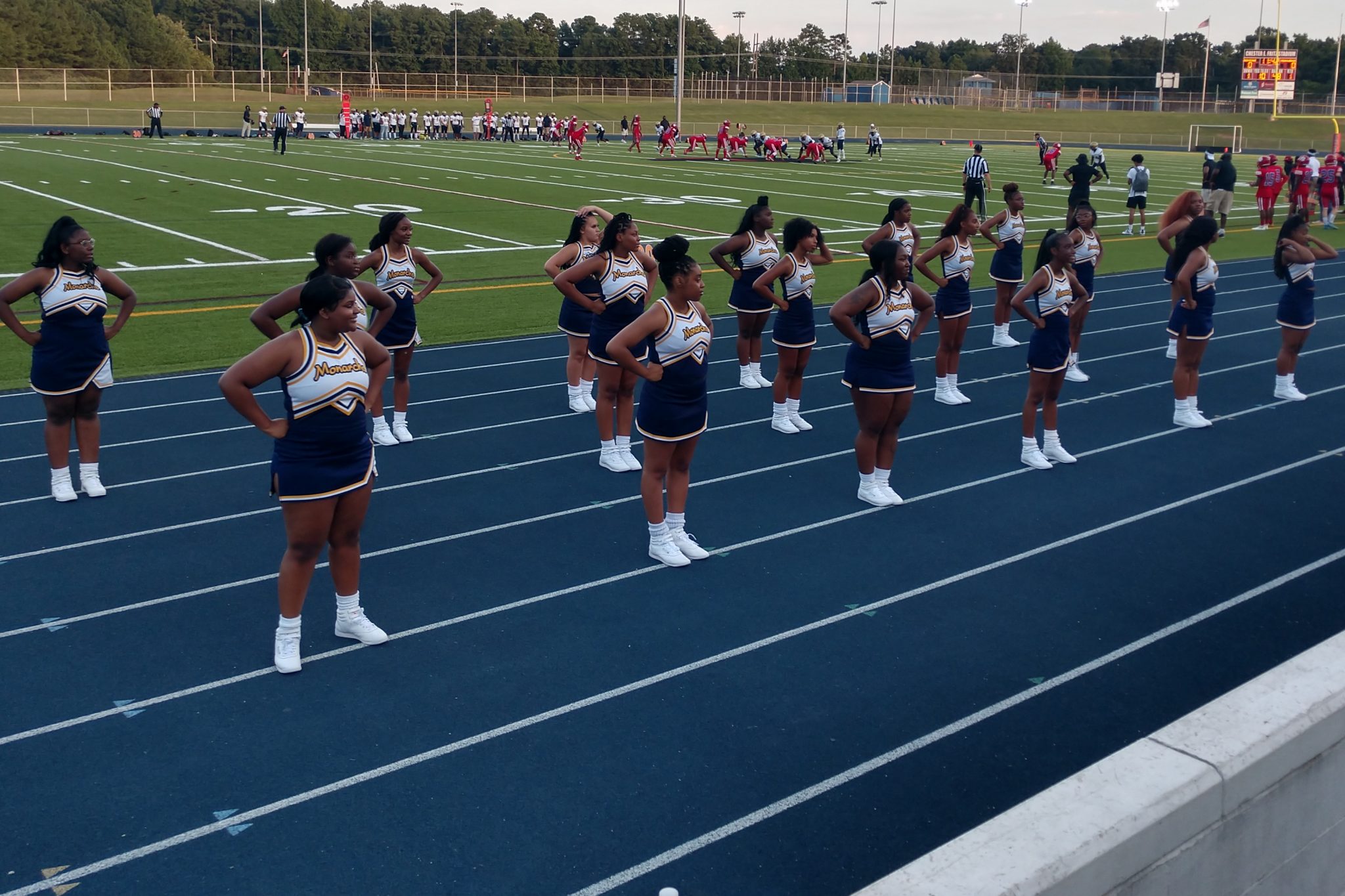 The cheer team performing outside during a football game