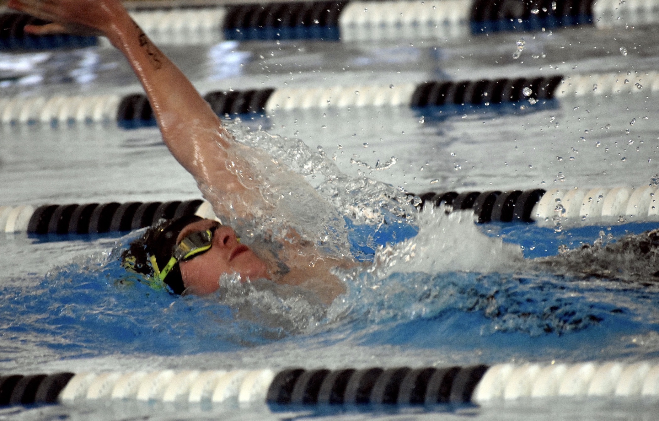 Abbey Burnham swims through the water in the 100-yard backstroke on Friday afternoon at the Roosevelt Aquatic Center