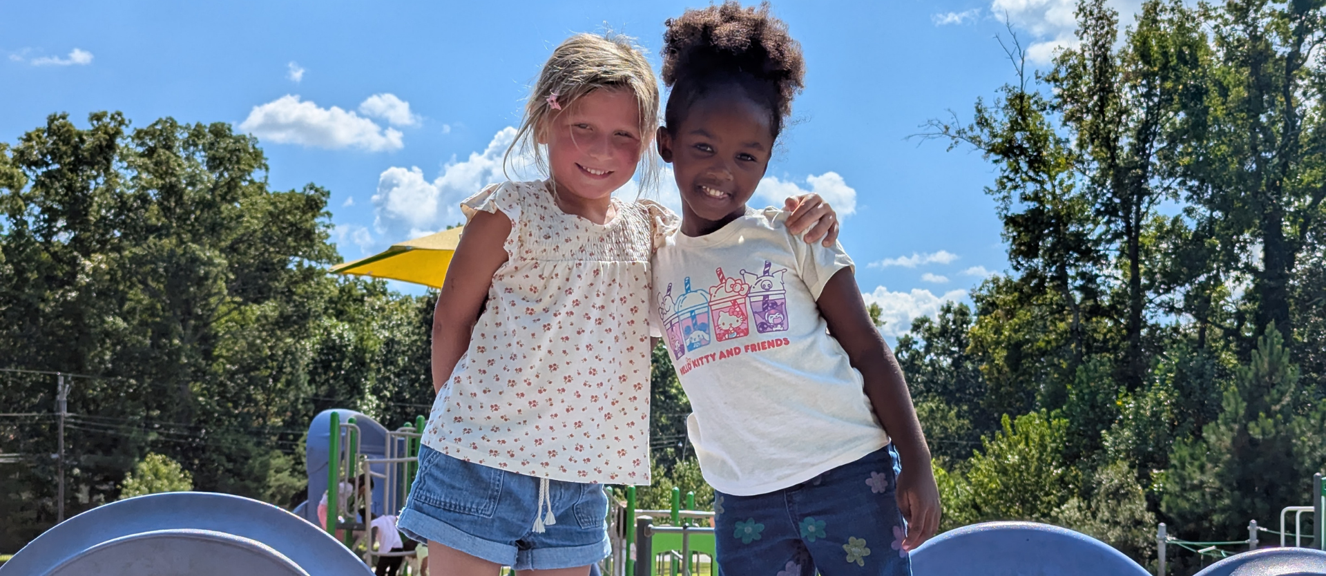 two students pose for a photo outside on the playground