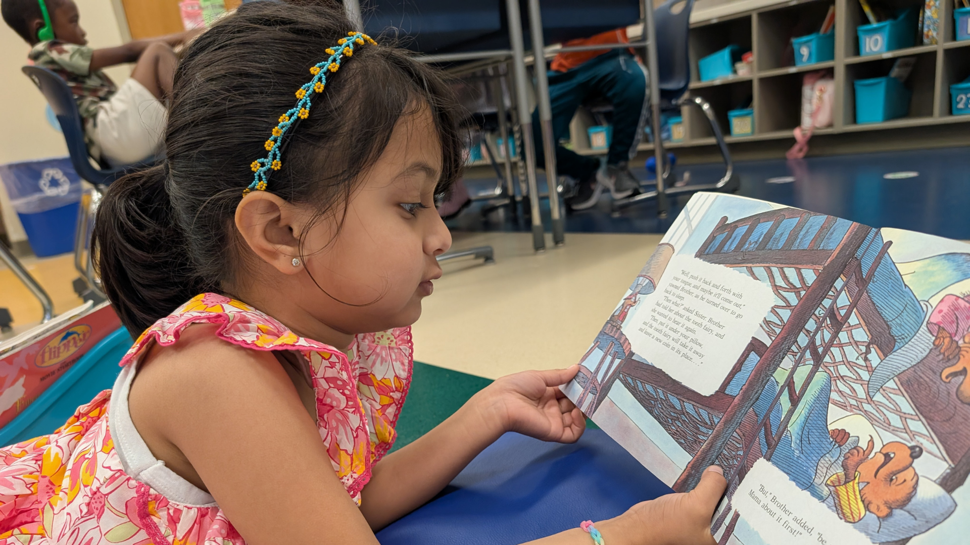 Student is reading a bookson the carpet